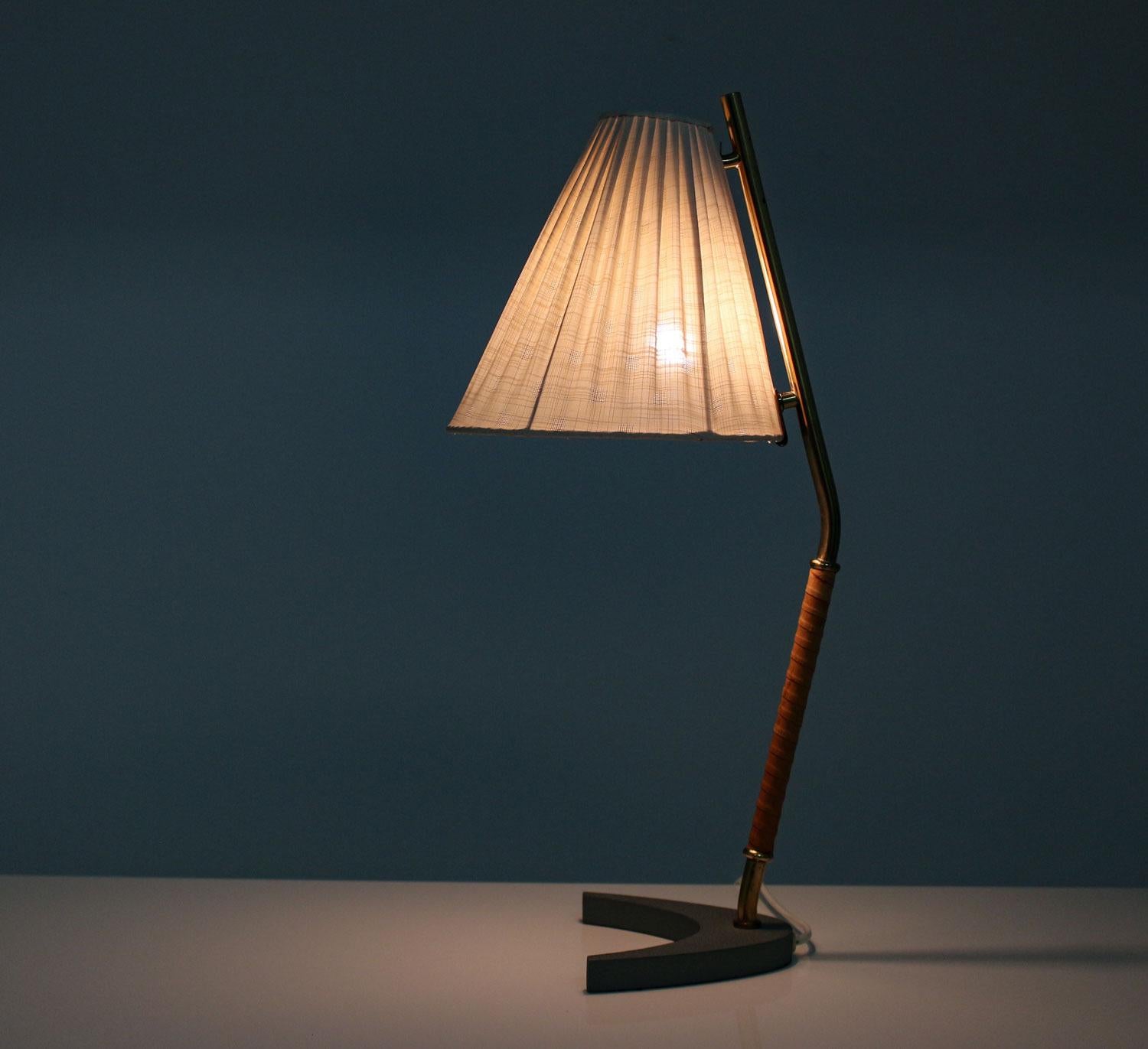 A desk lamp by Swedish manufacturer Arvid Böhlmarks Lampfabrik, model 15616.
This rare table lamp is made of brass with a leather handle, standing on a heavy V-shaped metal vcfrv foot. The shade is attached to the body with a slight distance to the