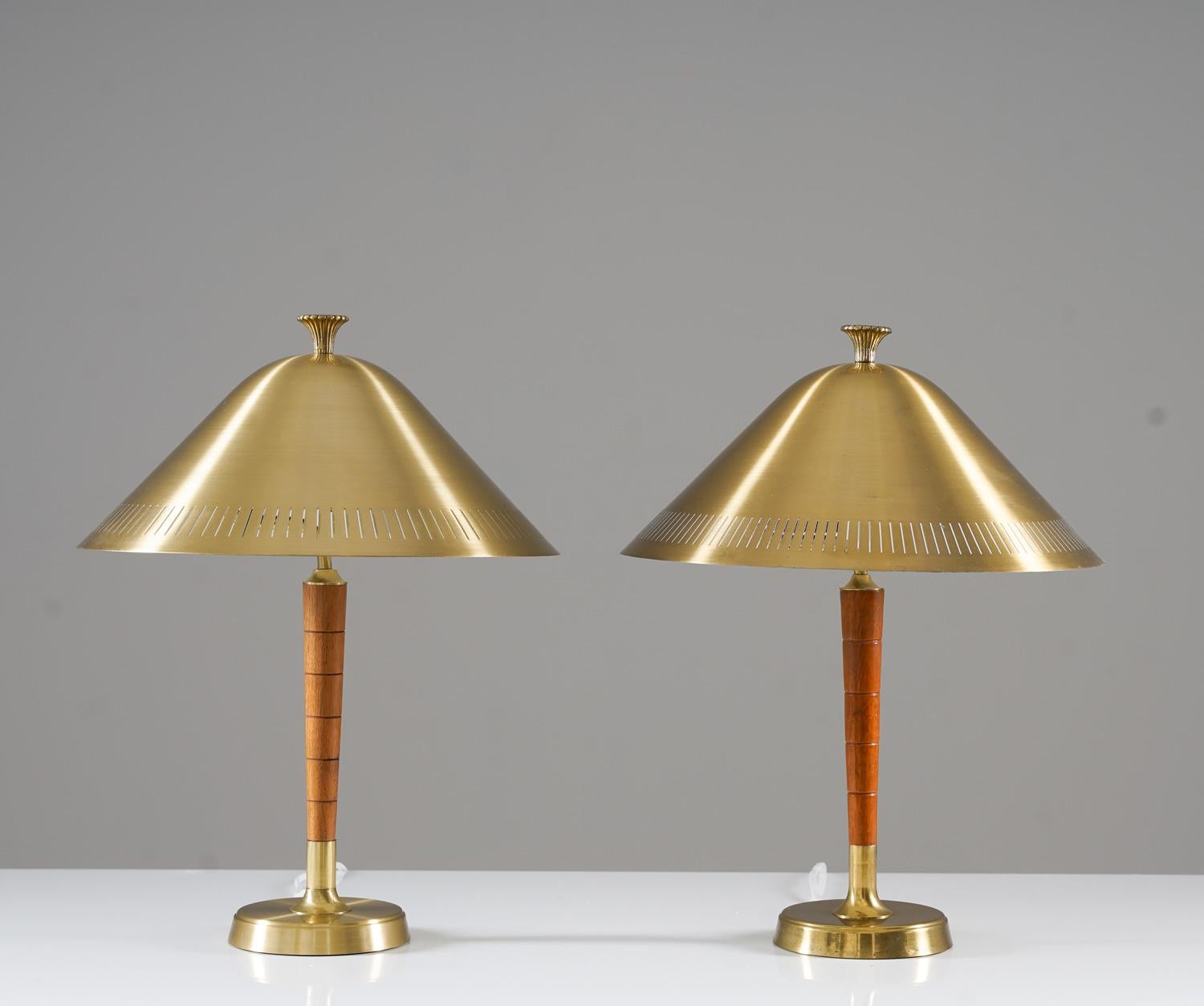 Schöne Tischlampen, hergestellt von Falkenbergs Belysning, Schweden.
Die Lampen haben einen großen perforierten Messingschirm, der die Glühbirne verdeckt. Die Schirme werden von Messingstäben mit Holzdetails getragen. 

Zustand: Guter