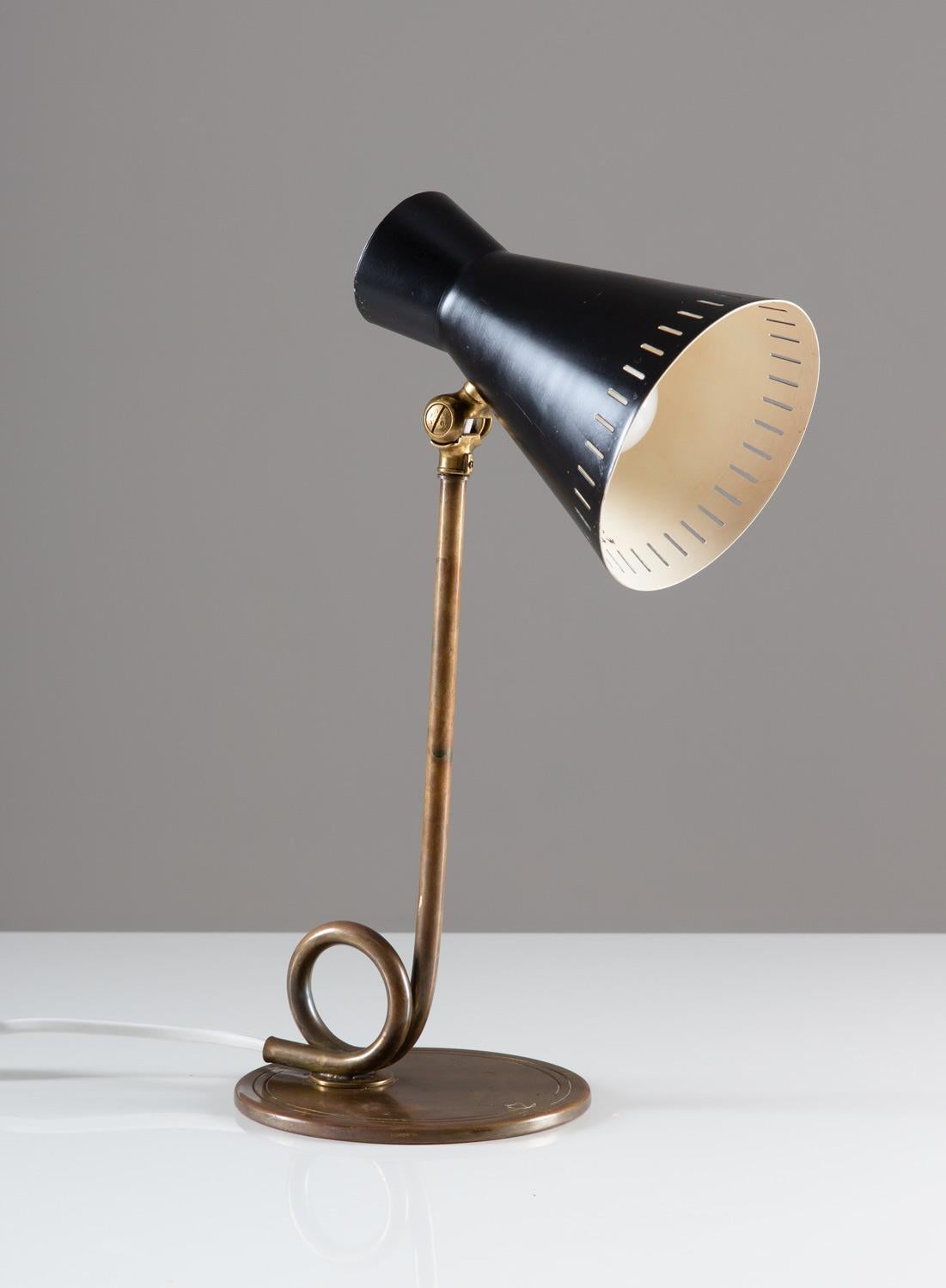 A charming desk lamp in brass produced in Sweden by E.A.E. 
This lamp consist of a brass base with a perforated black metal shade.

Condition: Good original condition with a soft patina and minor dents on the shade.