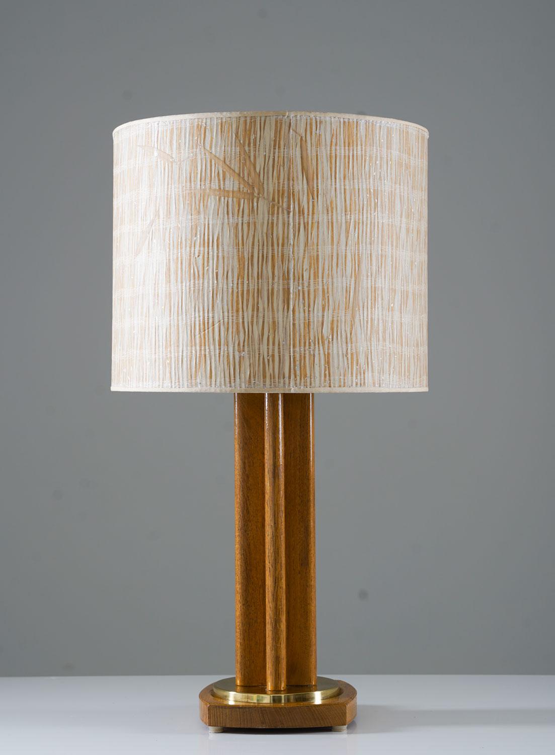 Large Scandinavian midcentury table lamp in oak and brass by Möllers Armatur Elektriska, Sweden, 1950s. 
This lamp is made of oak with details in brass. The lamp comes with a stunning vintage cylinder-shaped shade decorated with leaves of grass.
