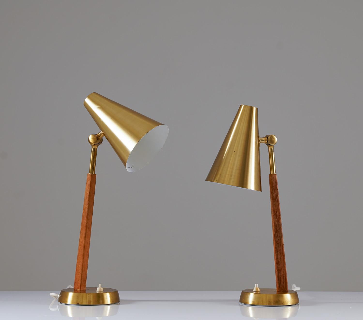 Beautiful table lamps manufactured by Falkenbergs Belysning, circa 1950.
These lamps are made of brass, with details in oak. The light sources are hidden by beautiful cone-shaped brass shades. 
Price is per lamp.

Condition: Good original