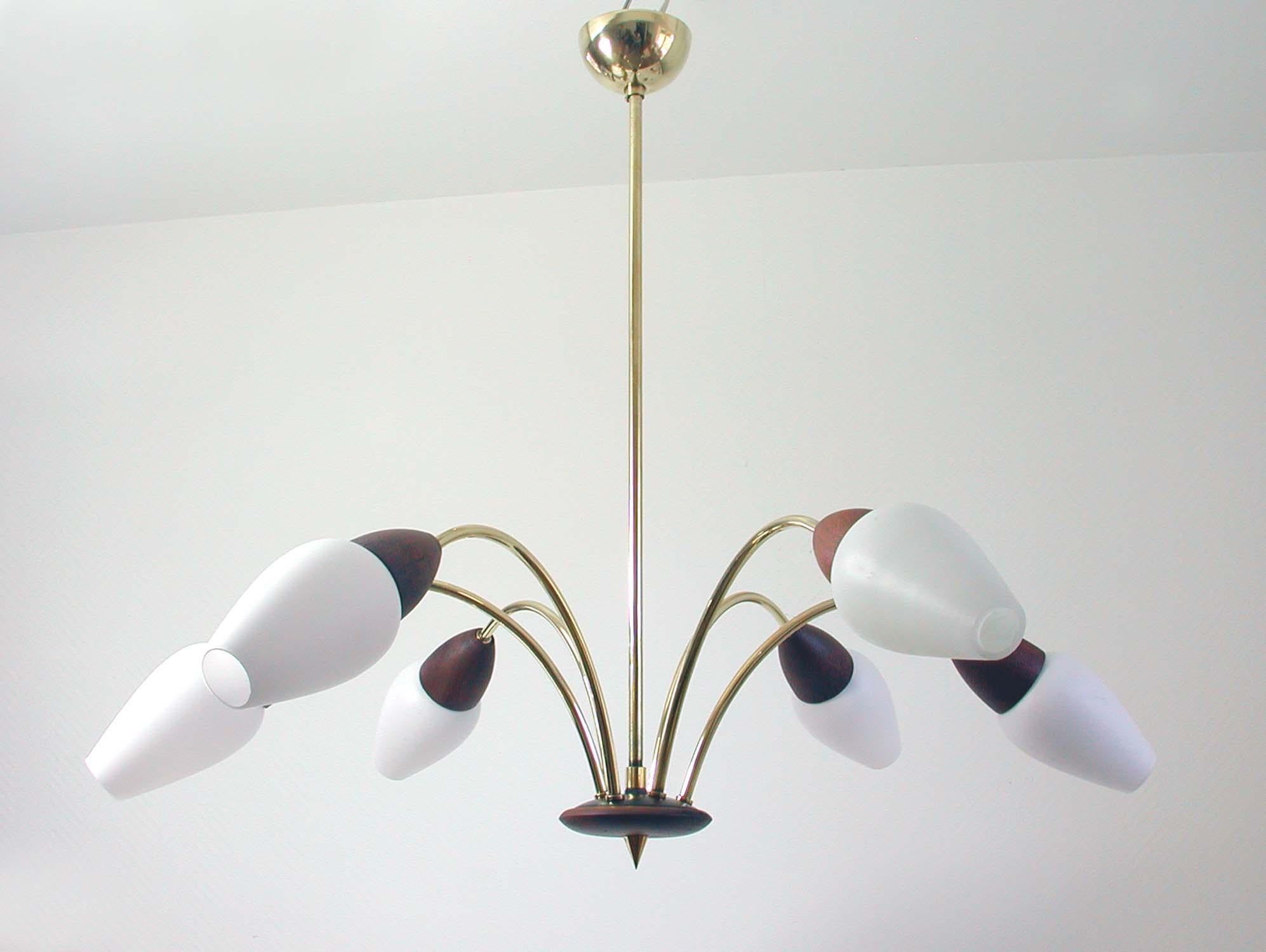 This six-light chandelier was manufactured in Denmark in the late 1950s-early 1960s. It is made of brass and teak and has got six opal glass lampsshades.

Condition is in excellent and the lamp is in full working order, cleaned and all brass