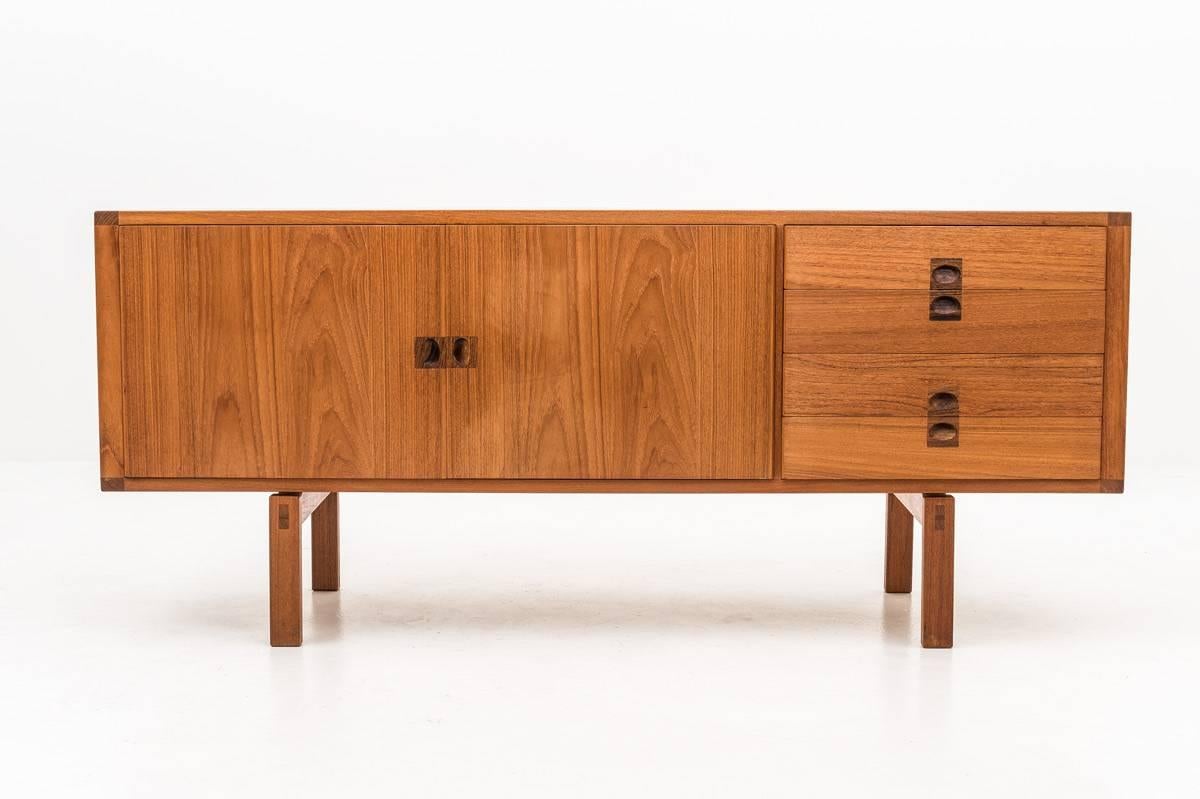 Scandinavian midcentury teak sideboard by Lennart Bender for Ulferts, Sweden.
This high-quality sideboard is made of solid wood with teak veneer and details of rosewood. The space above the legs gives this sideboard lightness and elegance, together