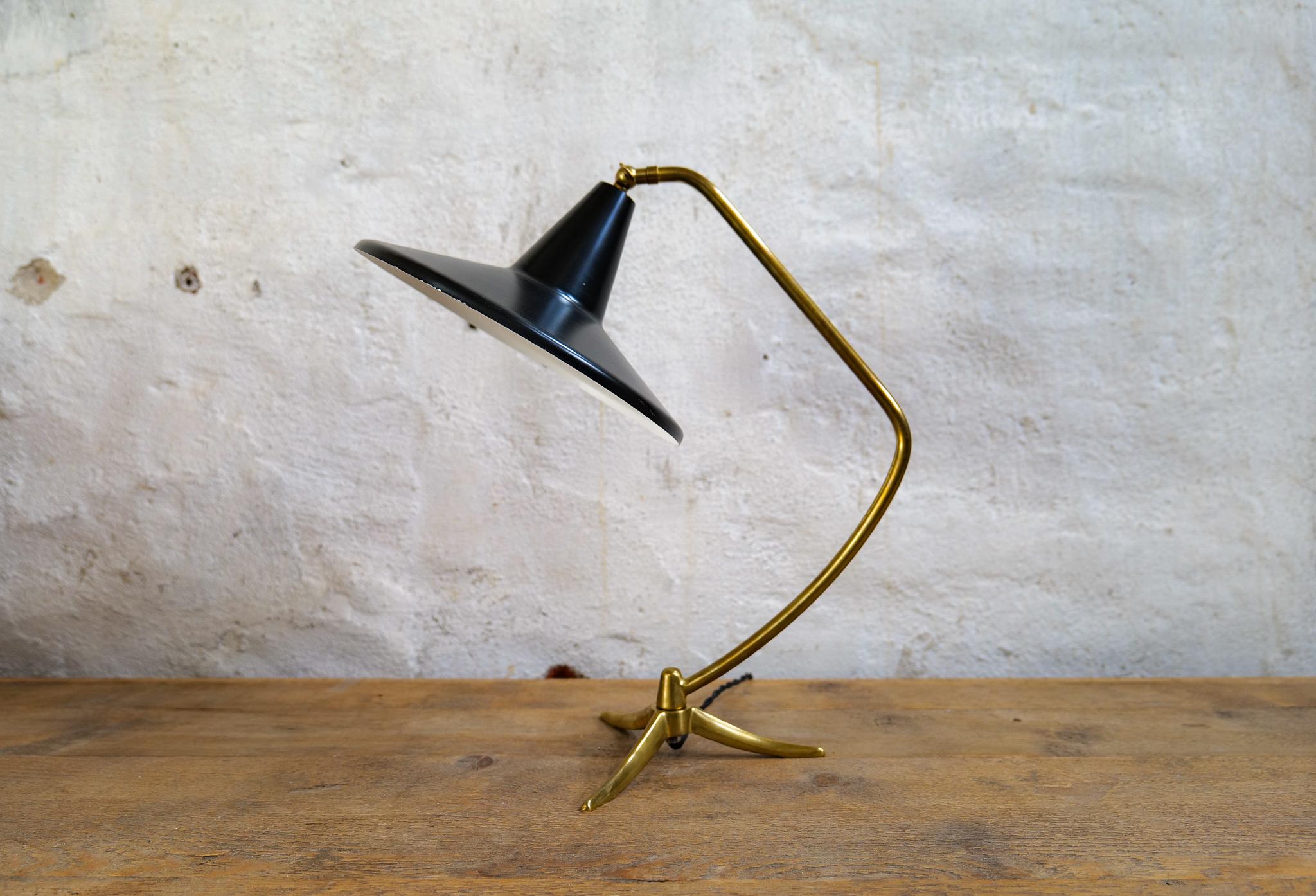 Elegante schwedische Tischlampe aus dem Jahr 1950, die ASEA zugeschrieben wird. Ein solider dreibeiniger Messingfuß mit Messingstab, der zu einem schwarz patinierten Schirm führt, ist eine schöne Kombination. Der Schirm und der Stab sind