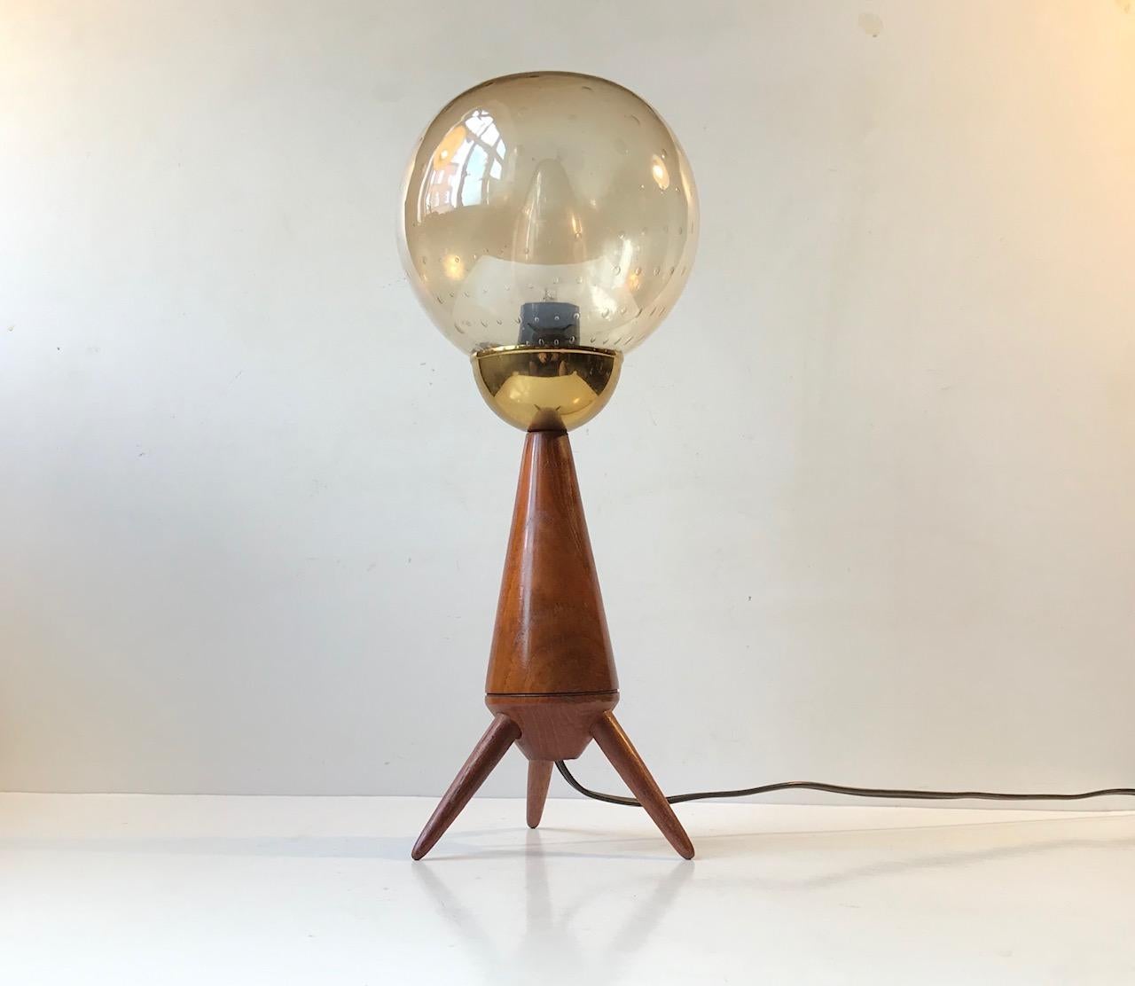 Shaped as a Satellite or Lunar Landing vehicle this unusual table light made from solid teak, brass and handblown bubble glass demands attention. Made/designed anonymously in Scandinavia during the 1960s. Stylistically it corresponds with similar