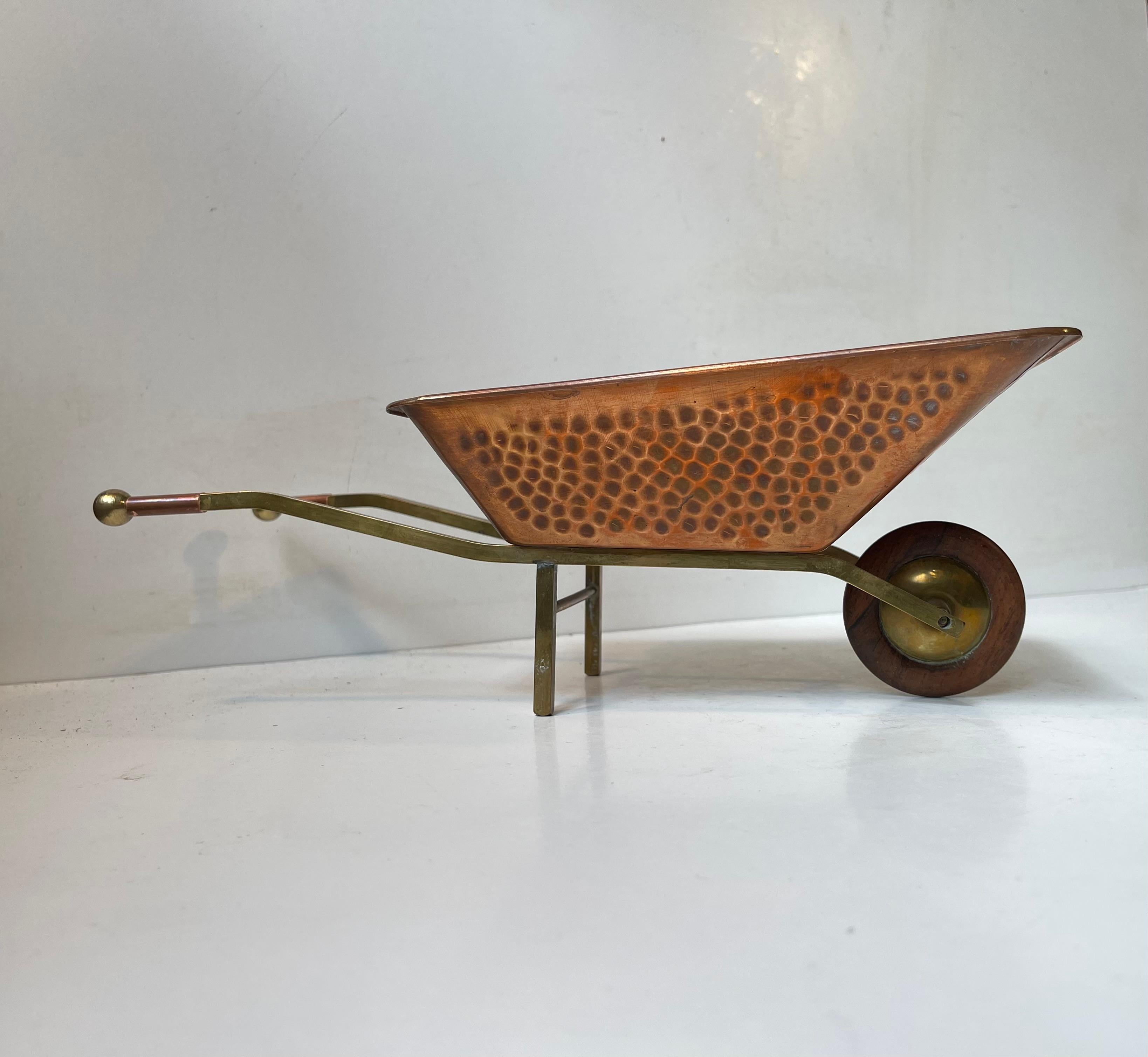 No stone is left unturned when it comes to the quality and craftsmanship of this midcentury miniature wheelbarrow planter (31x15.5x11.5 cm). It is executed in hammered copper, has a frame in brass and a turning wheel on Rosewood. Unknown
