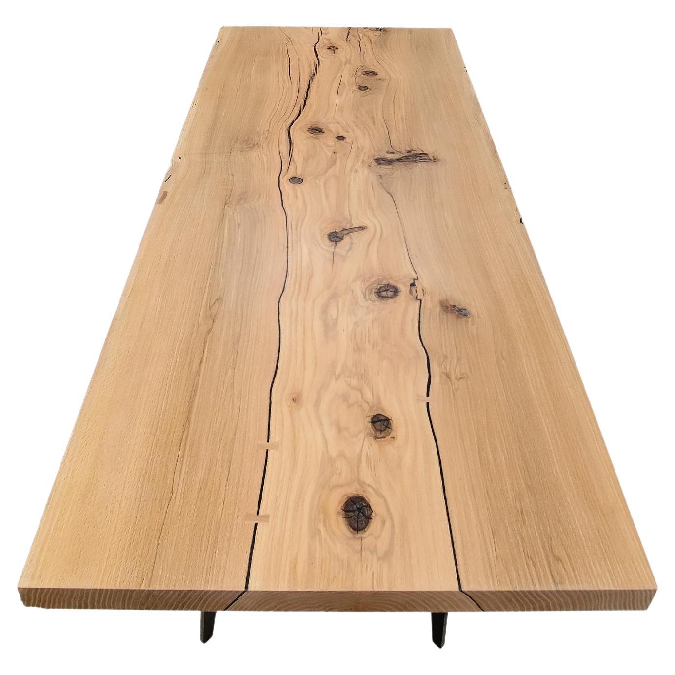 A substantial, thick slab of Canadian Red Oak atop a cold-rolled steel base showcases the clean lines and minimal design of this dining or conference table. Featuring hand-crafted Red Oak butterfly inlays to support the natural texture and reinforce