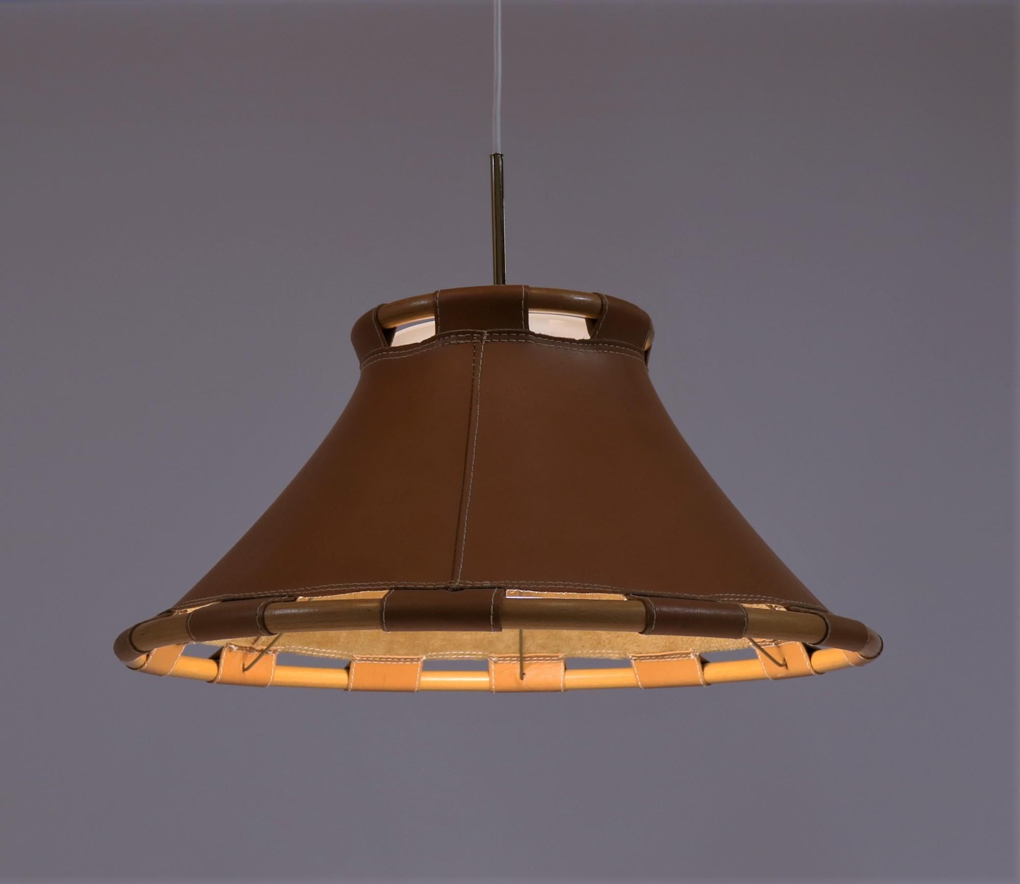 Erstaunliches schwedisches Design von Anna Ahrens für Ateljé Lyktan, Schweden, 1970er Jahre. Der Schirm besteht aus Sattelleder und gebogener Buche mit schönen Messingdetails und einem Acryldiffusor. Die Lampe wurde mit einer weißen Stoffschnur neu