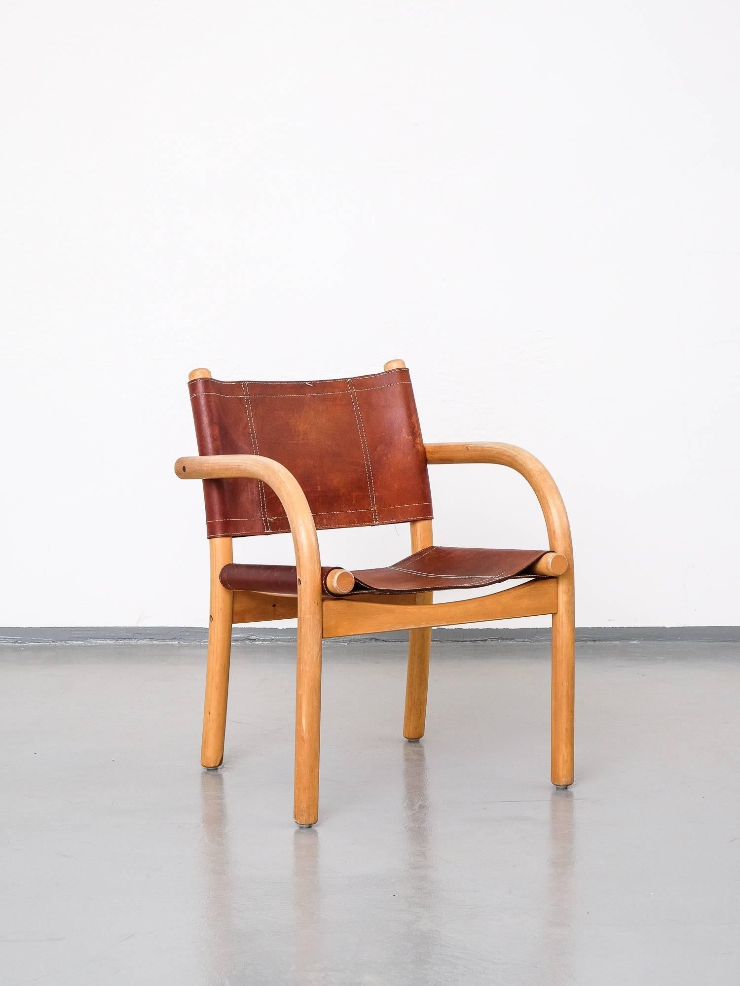 Classic safari chair designed in 1974 by Ben af Schultén for Artek. Birch frame with seat and back in natural leather. Heavy patina on leather and worn armrests. Measures: Seat height 43 cm.