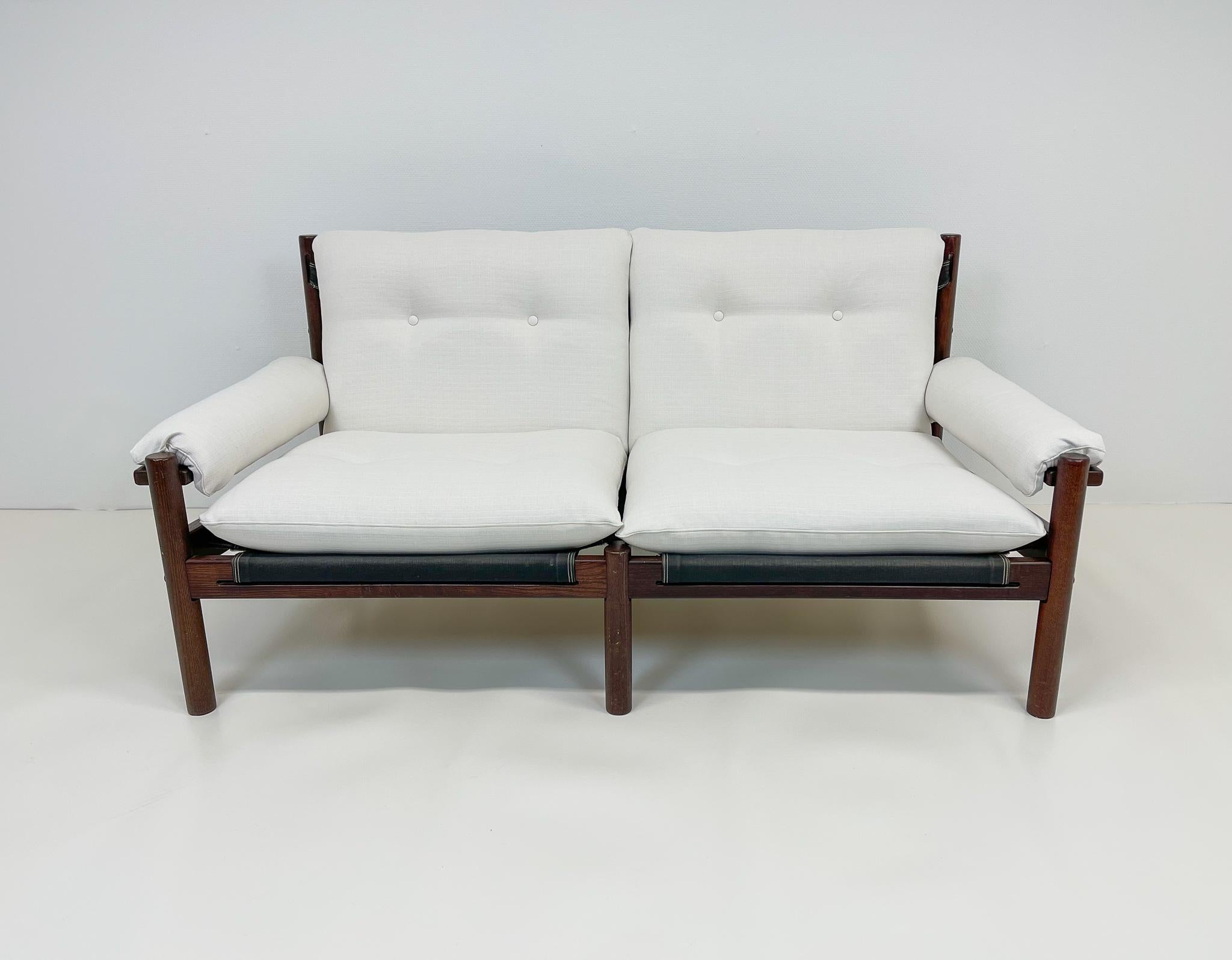 This sofa is a perfect example of minimalist Scandinavian design. Made in stained wood with canvas back, and all new upholstery in white textile. 
We have 2 pieces of this sofa. 

Good vintage condition, small marks on the wood. 

Dimensions W