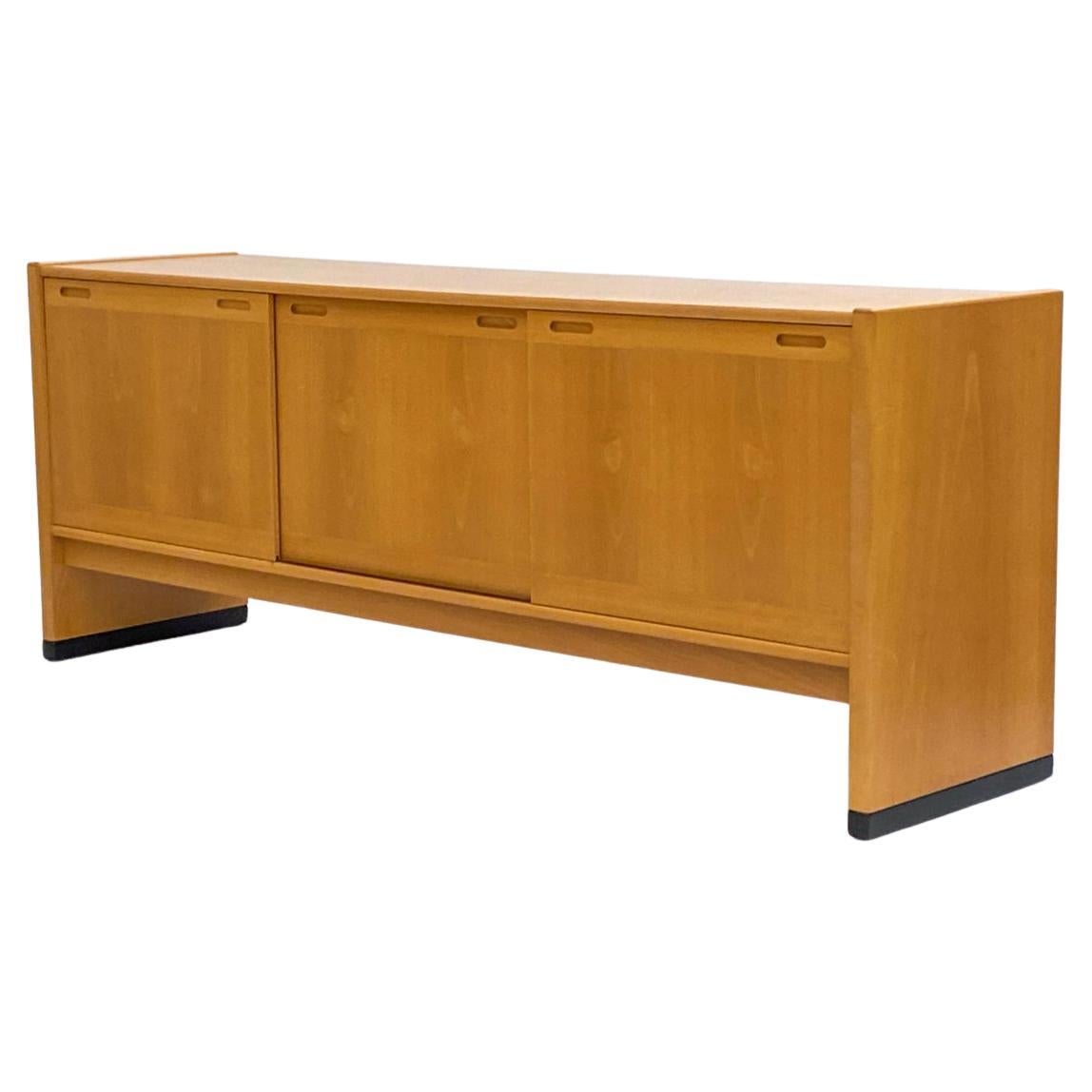 Scandinavian modern 3 sliding door blonde beech long credenza by Skovby. This credenza has very simple design and lines in blonde maple finish. Has 3 front sliding cabinet doors with 2 drawers on the left and 2 adjustable shelves behind middle and