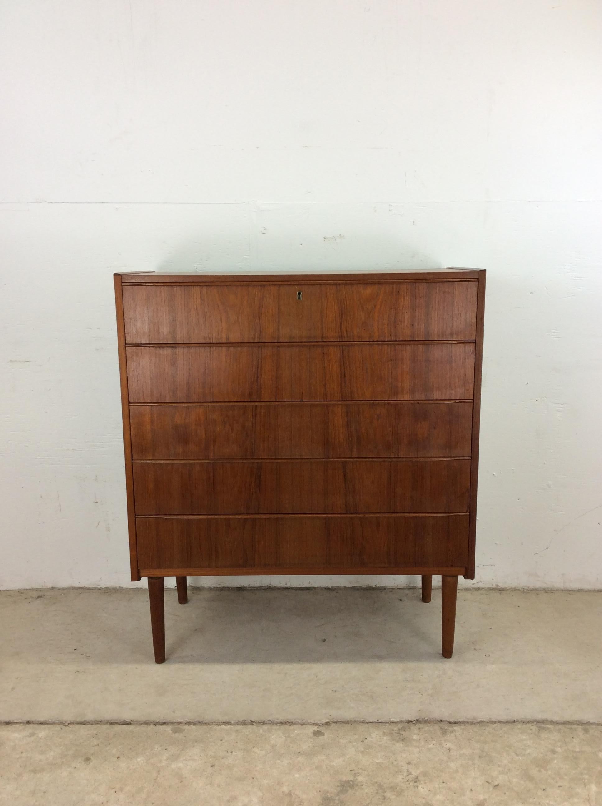 Questo comò moderno scandinavo è realizzato in legno massiccio, impiallacciato in teak con finitura originale, cinque cassetti a coda di rondine con esclusivi tiretti in legno, serratura in ottone con chiave e alte gambe affusolate.

Dimensioni: 35w