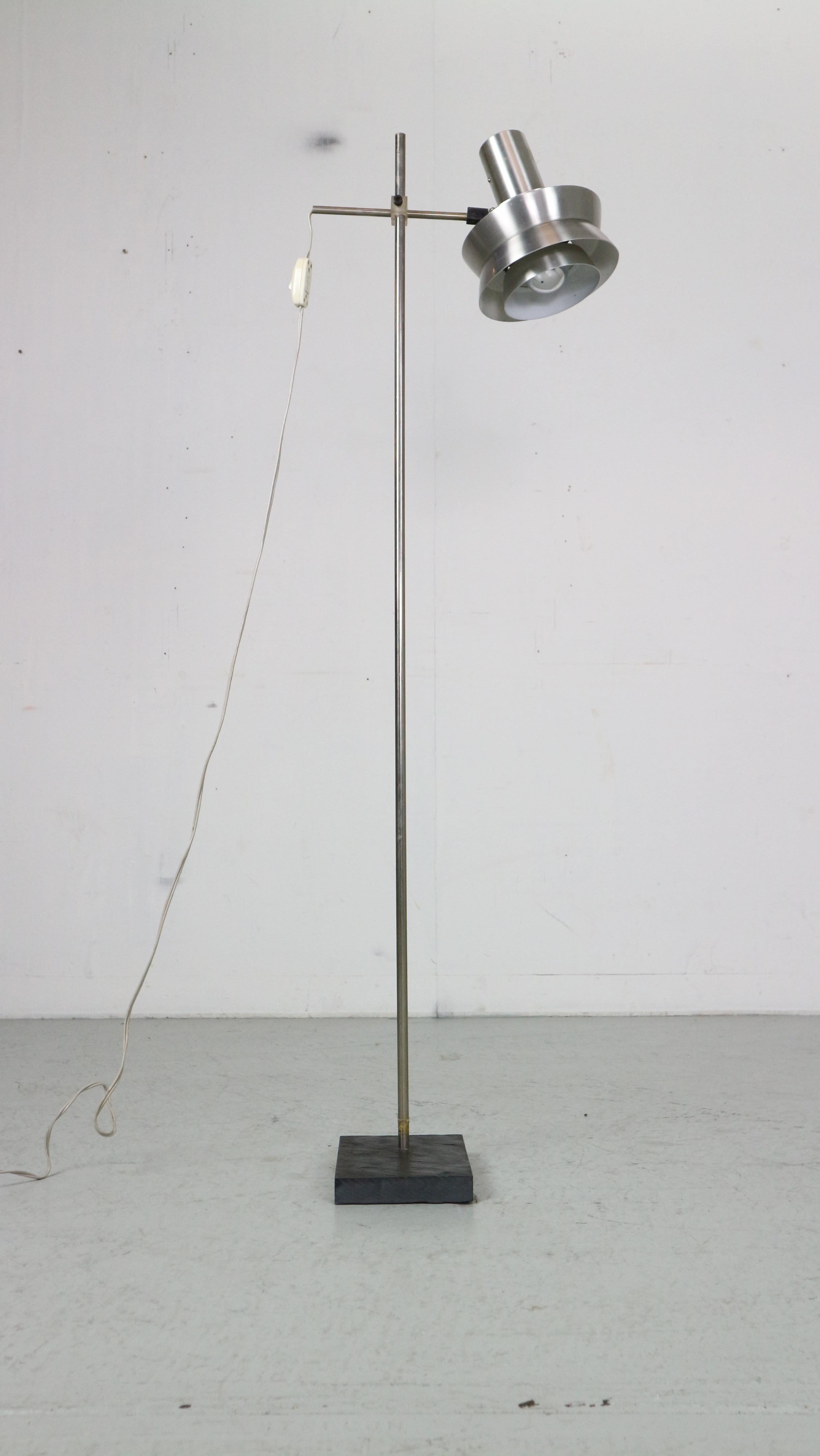Scandinavian modern period floor lamp designed in 1970's period, Denmark.

Chrome metal lamp shade is in two colours- silver and red and has an on/off button.
You can adjust the lamp shade's high and direction.
The light standing on a stone
