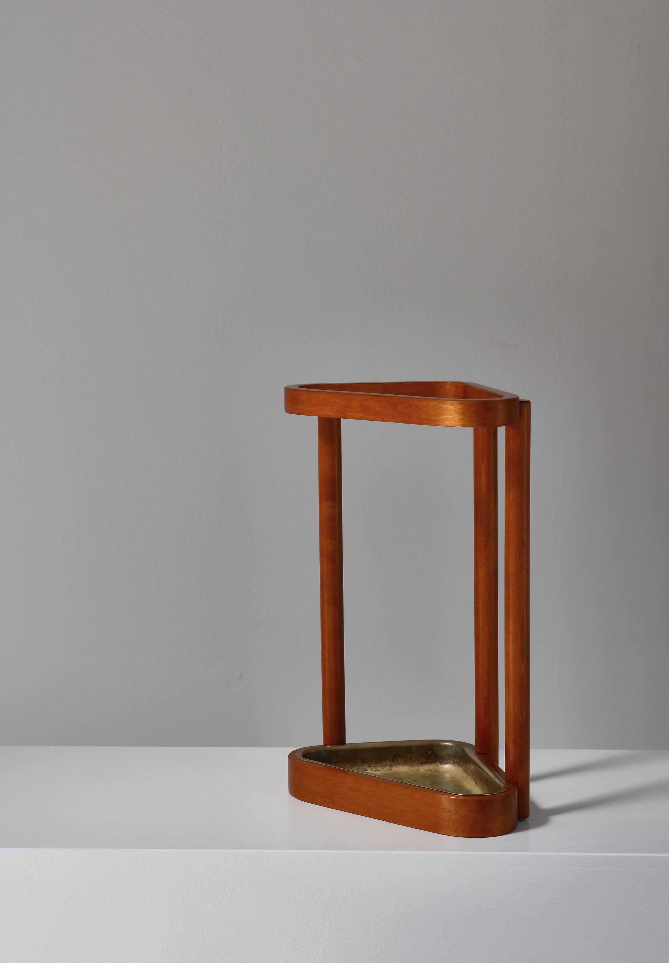 Rare porte-parapluie modèle no. 115 conçu par Alvar Aalto en 1936. Cet exemplaire a été fabriqué dans les années 1940. Ce porte-parapluie réunit le bouleau et le laiton dans une structure composée de trois piliers en bouleau massif unis par deux