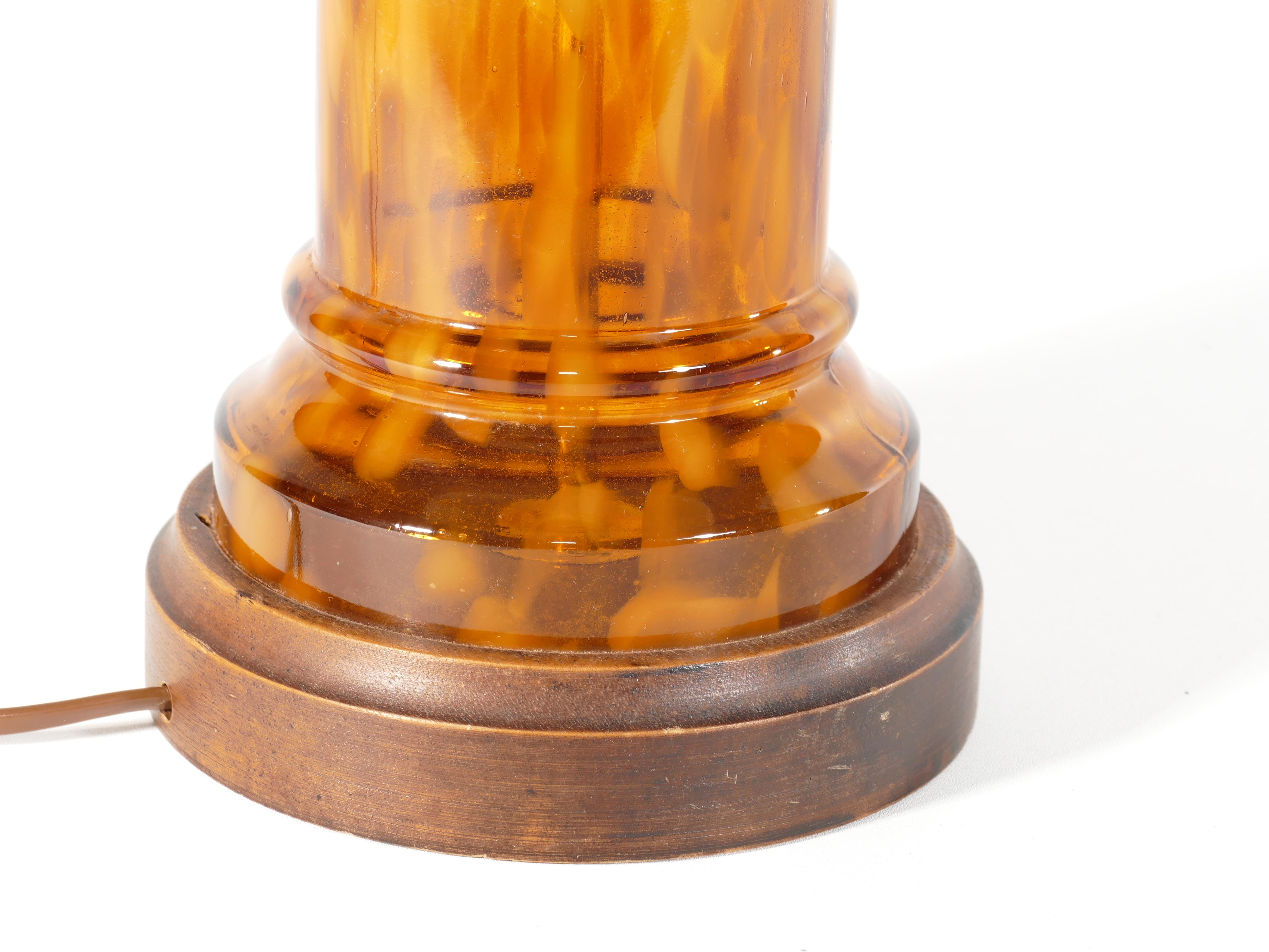 The warm amber glass with darker patches diffuses light in a captivating, inviting manner, creating a cozy atmosphere that radiates charm. 

 Whether gracing your living room, bedroom, or office, this lamp is a statement piece that effortlessly