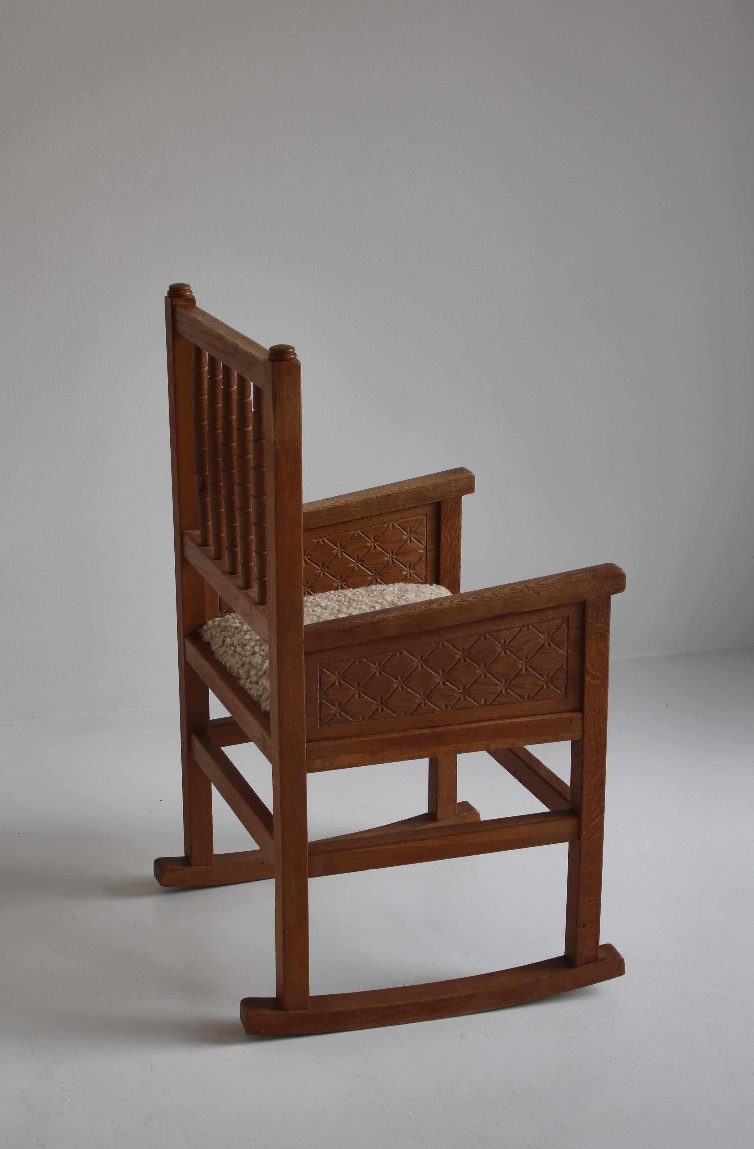 Danish Cabinetmakers Carved Rocking Armchair in Sheepskin and Oak, Denmark, 1930 For Sale