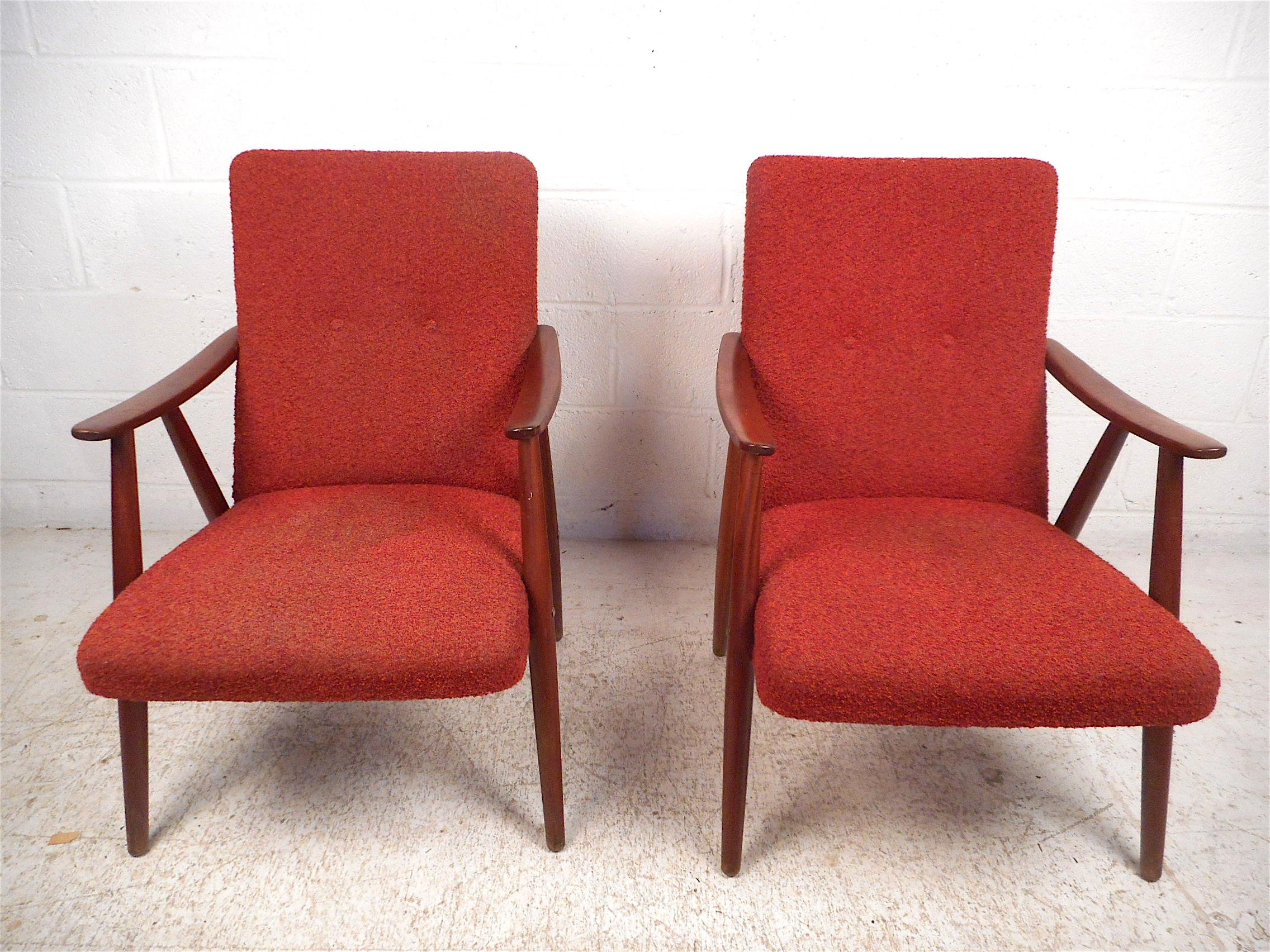 Rare pair of Scandinavian Modern armchairs by the Norwegian manufacturer Langlo's Fabrikker. Stylish angular frame with sculpted armrests and tapered legs. Splayed legs along with the sloped backrests give these chairs an impressive visual profile.