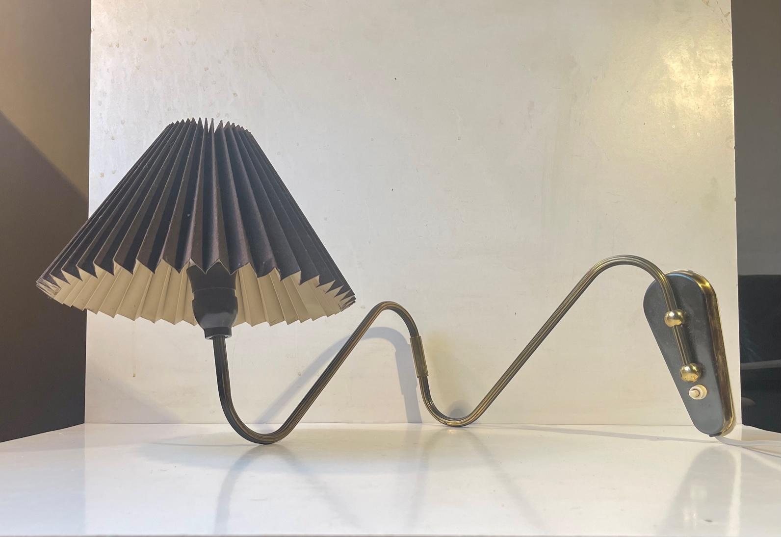 Fully adjustable wall lamp composed of a brass 'body' installed with a black fluted textile and paper shade. It was designed and manufactured in Scandinavia during the 1960s in a style reminiscent of Svend Aage Holm-Sørensen. The reach of this