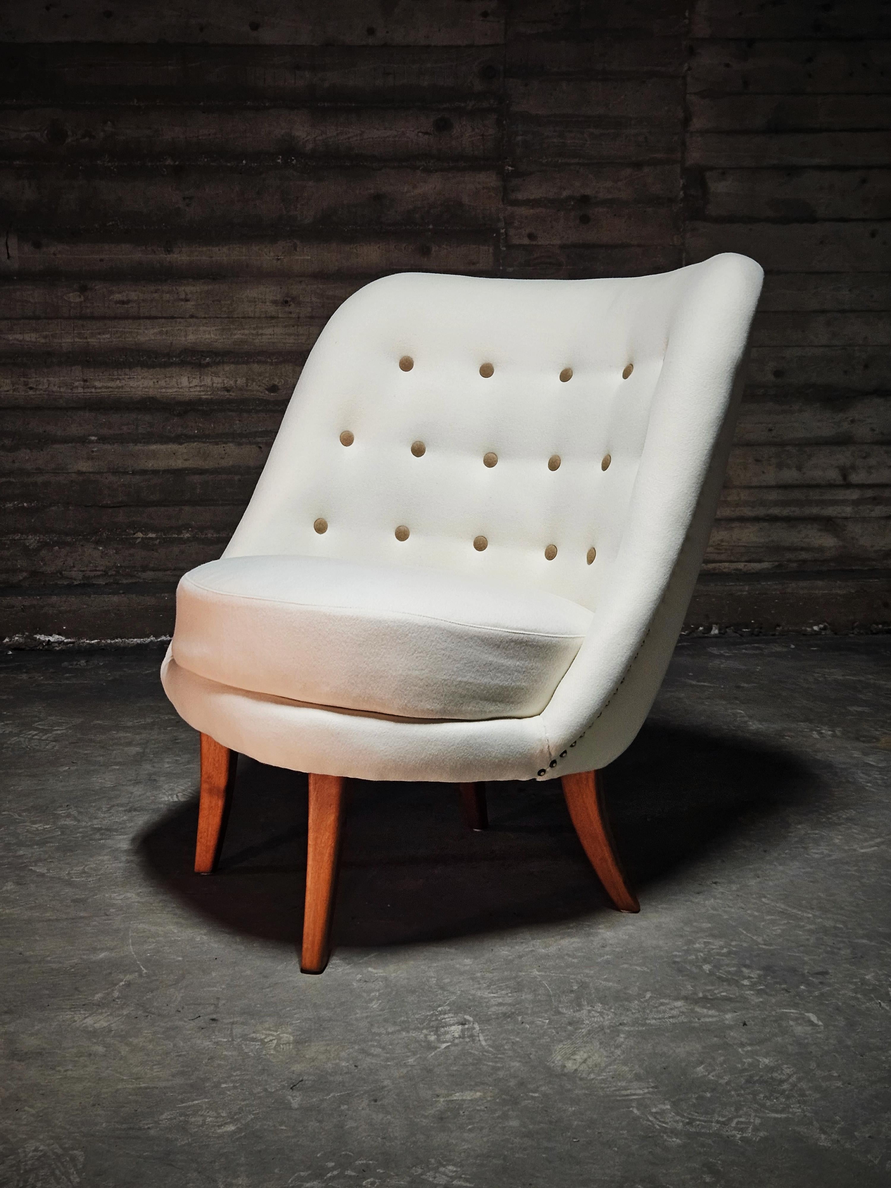 A Scandinavian modern asymmetrical lounge chair, designed by Arne Norell in the 1950s. 

Re-upholstered with high quality white wool with brown wool buttons. 
