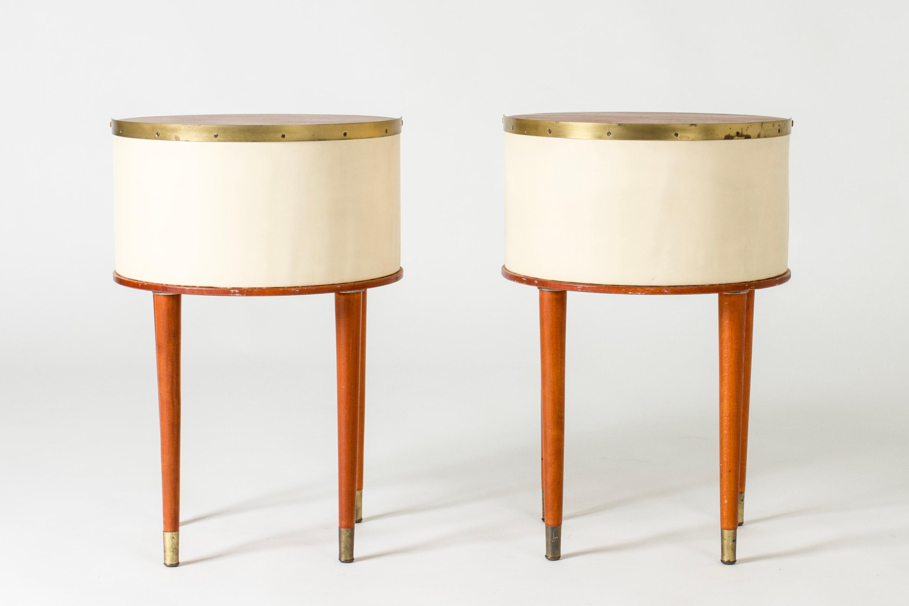 Pair of lovely bedside tables by Halvdan Pettersson. Teak table tops lined with brass rims in half circles, body dressed with faux leather and decorated with brass nails. Beech legs with brass feet.