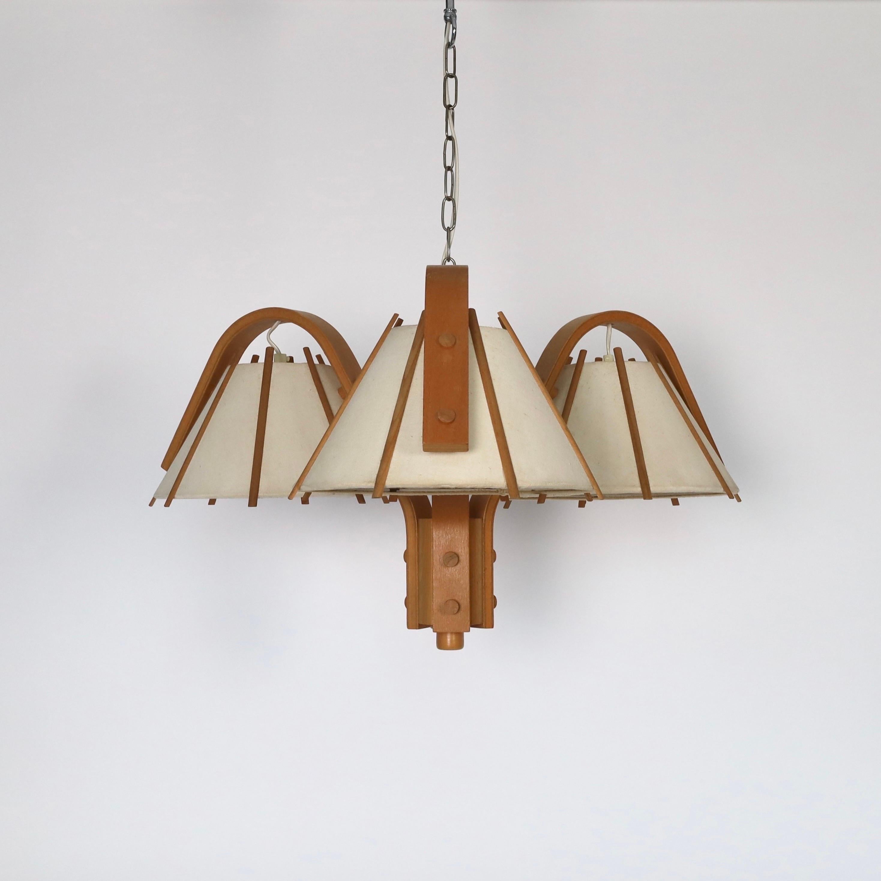 Impressive Scandinavian Modern Beech Wood Chandelier designed by Jan Wickelgren in the 1970s for Aneta Sweden. A center-piece for a beautiful home.
 
* Pendant light in bend beech wood with three shades in beige canvas
* Designer: Jan Wickelgren
*
