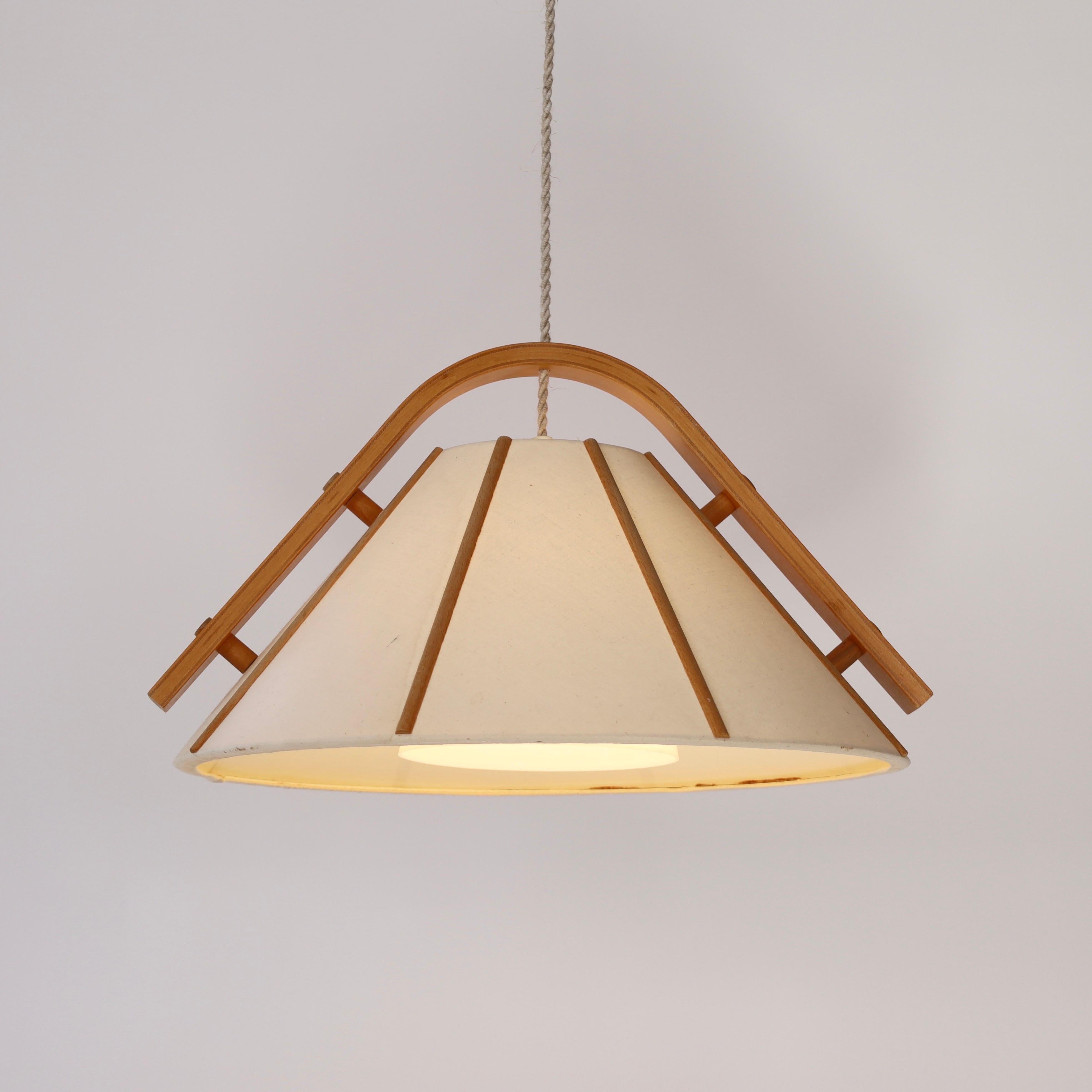 A pendant light in bend Beech wood with a Canvas shade designed by Jan Wickelgren in the 1970s for Aneta Sweden. A scandinavian light to a beautiful space. 

* A pendant light in bend beech veneer and beige canvas
* Designer: Jan Wickelgren
*