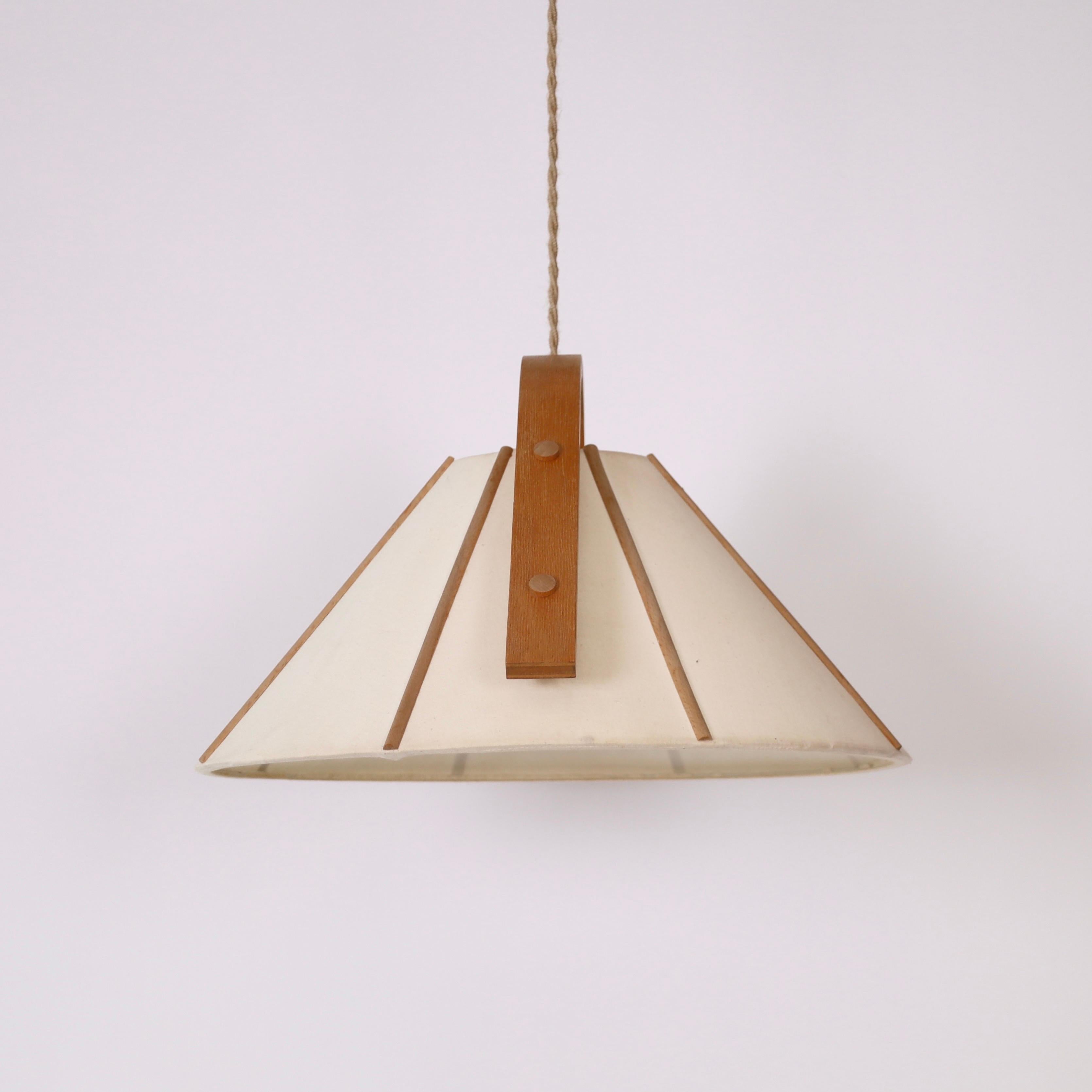 A pendant light in bend Beech wood with a Canvas shade designed by Jan Wickelgren in the 1970s for Aneta Sweden. A scandinavian light to a beautiful space.

* A pendant light in bend beech veneer and beige canvas
* Designer: Jan Wickelgren
*