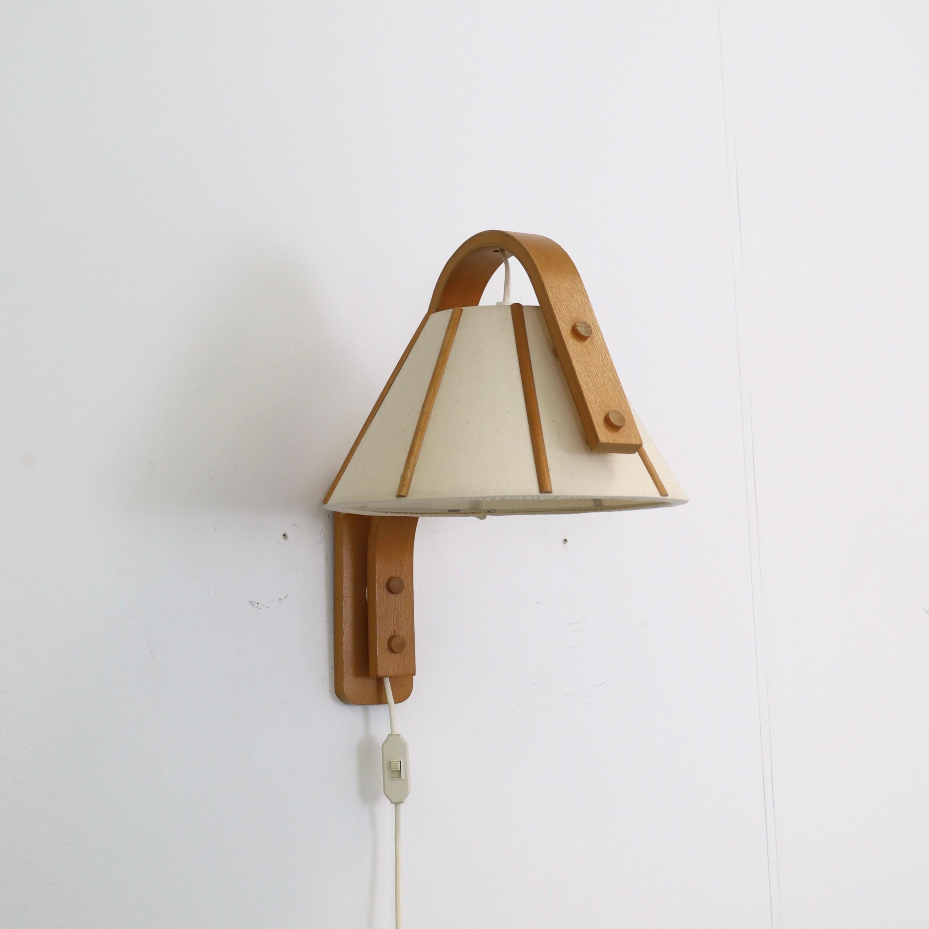 Scandinavian Modern wall lamp in bend Beech wood designed by Jan Wickelgren in the 1970s for Aneta Sweden. A Nordic touch for a beautiful home.

* A bend beech veneer wall lamp with a light cream-coloured shades in canvas
* Designer: Jan