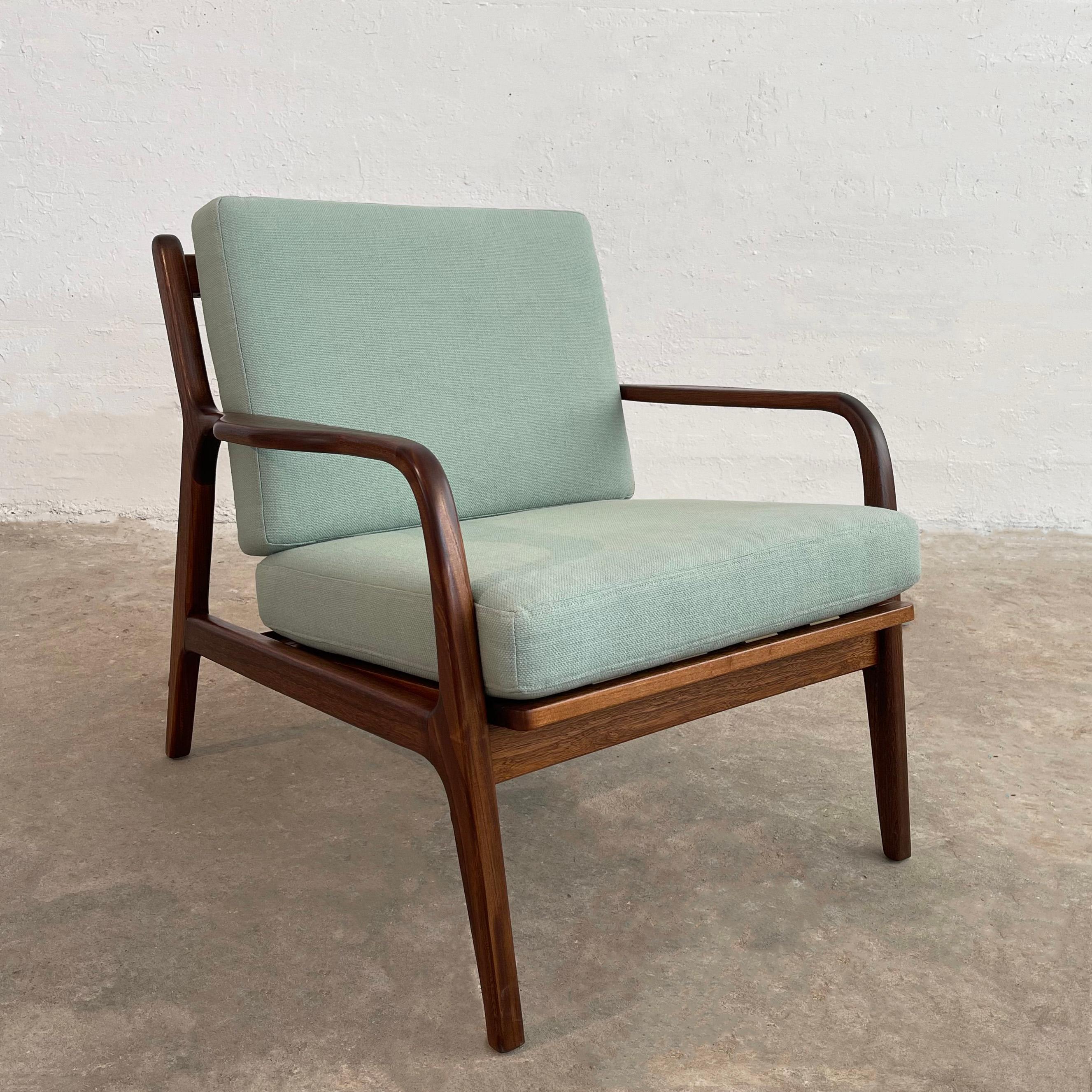 Classic, Scandinavian modern, lounge chair features a walnut frame with slat back and sculpted armrests and bentwood arms at 20.5 inches height. The cushions are newly upholstered in light blue linen cotton to contrast nicely with the dark walnut