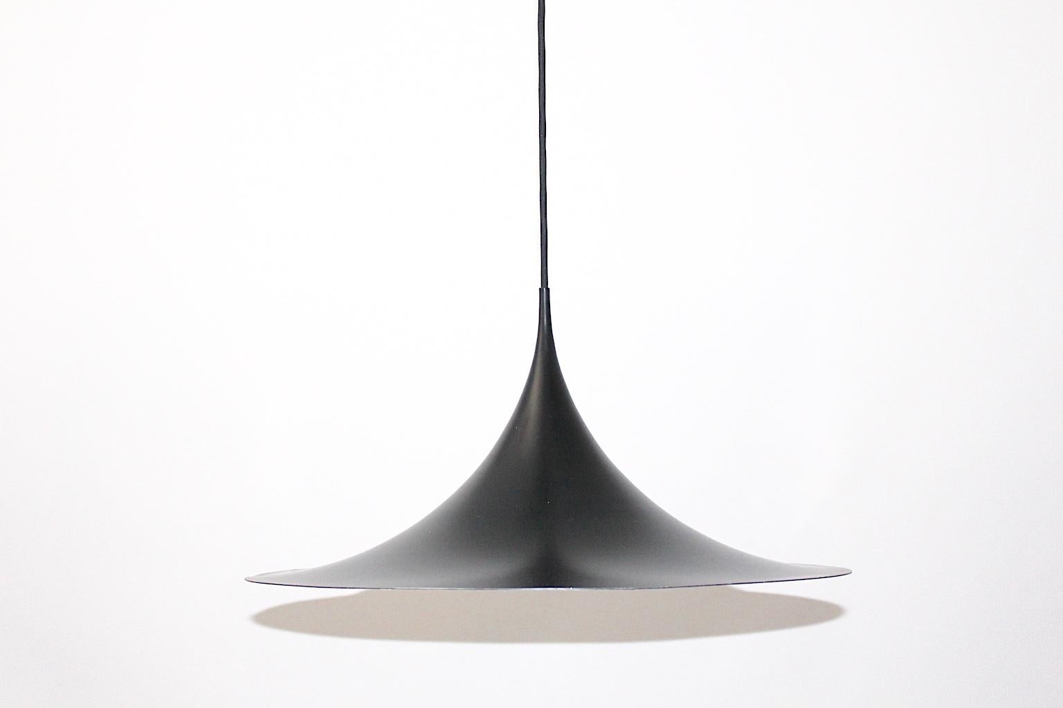 This vintage hanging light / pendant / chandelier was designed by Claus Bonderup and Thorsten Thorup, 1967 and produced by Fog & Mørup, Aalestrup, Denmark.
The iconic enameled white and black metal shade is shaped like a trumpet and shows one E 27