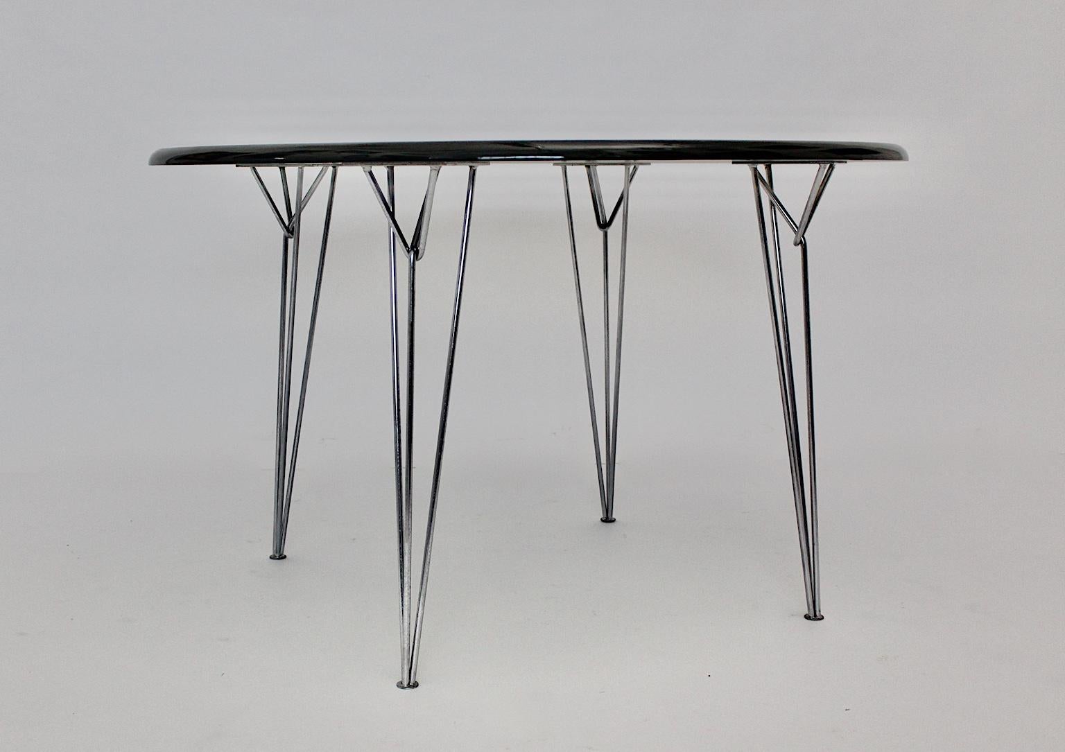 Scandinavian Modern black vintage dining table or center table, which shows
a hair pin metal base and a newly lacquered glossy fiberglass top.
The dining table stands out through its clean and minimalistic design features.
The vintage condition is