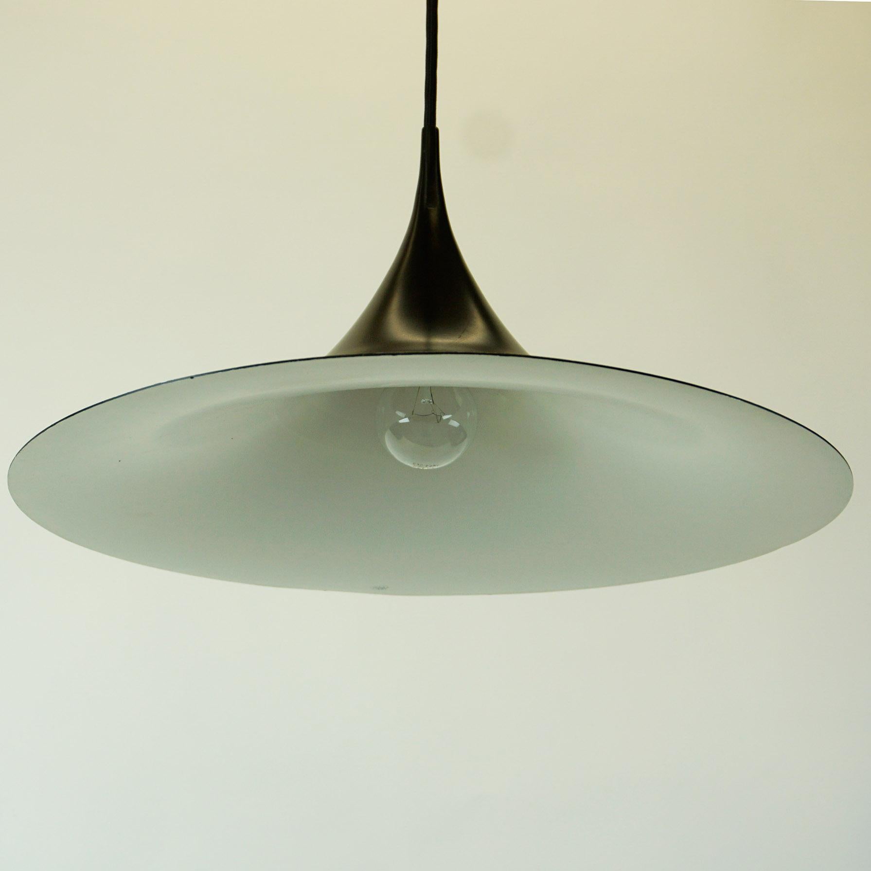 Black lacquered semi pendant lamp with off-white interior. The semi is one of the most iconic designs by Fog & Mørup. It is in very good condition with a few smaller signs of wear and has a 48 cm diameter, making it perfect over a dining or kitchen
