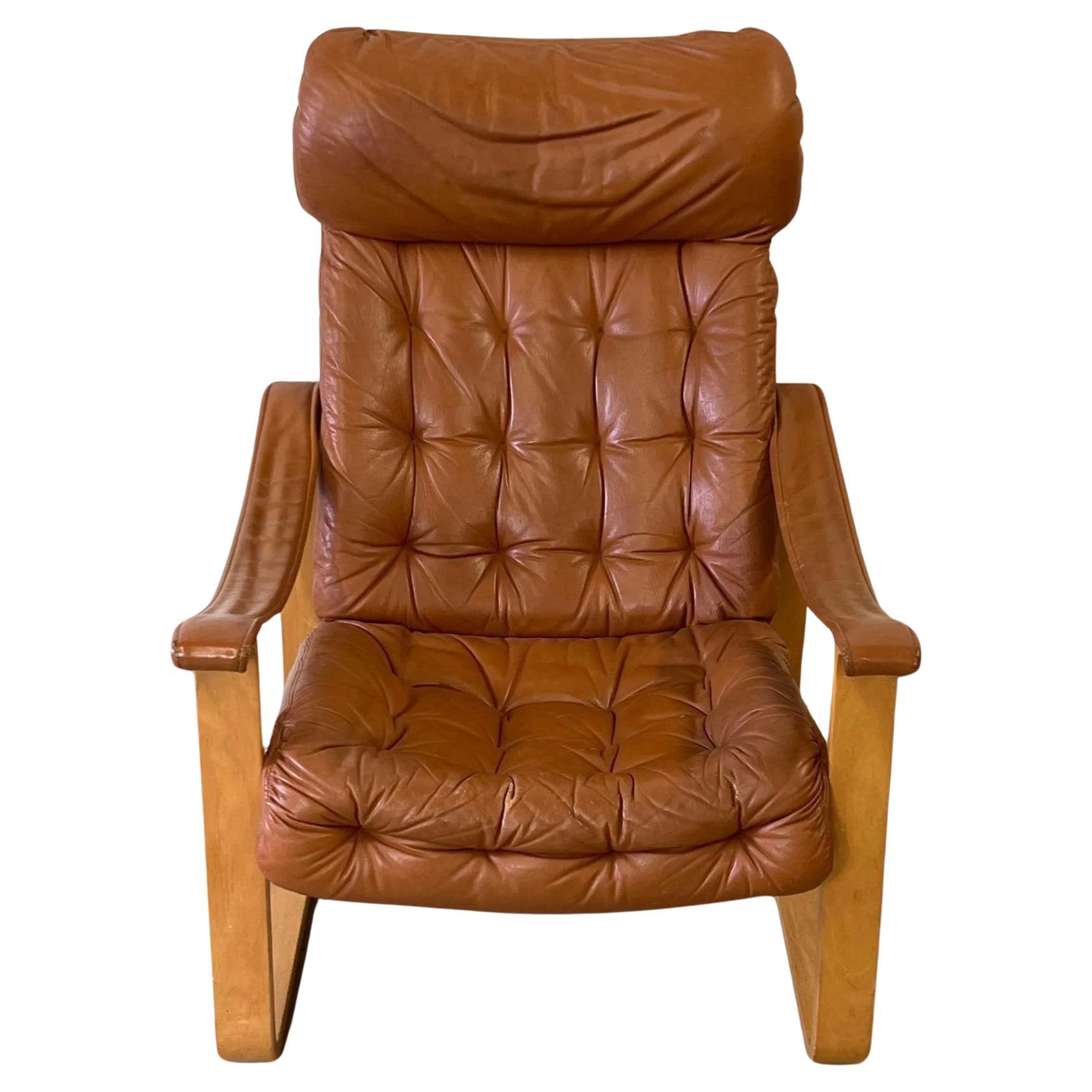 A leather sling lounge chair designed by Bjarne (BJ) Dahlqvist for Oy BD-Mobel Ab. This 1970s Finnish chair features a blonde bentwood frame, tufted leather seat and backrest, a leather headrest, leather sling armrests. Made in Finland. Located in