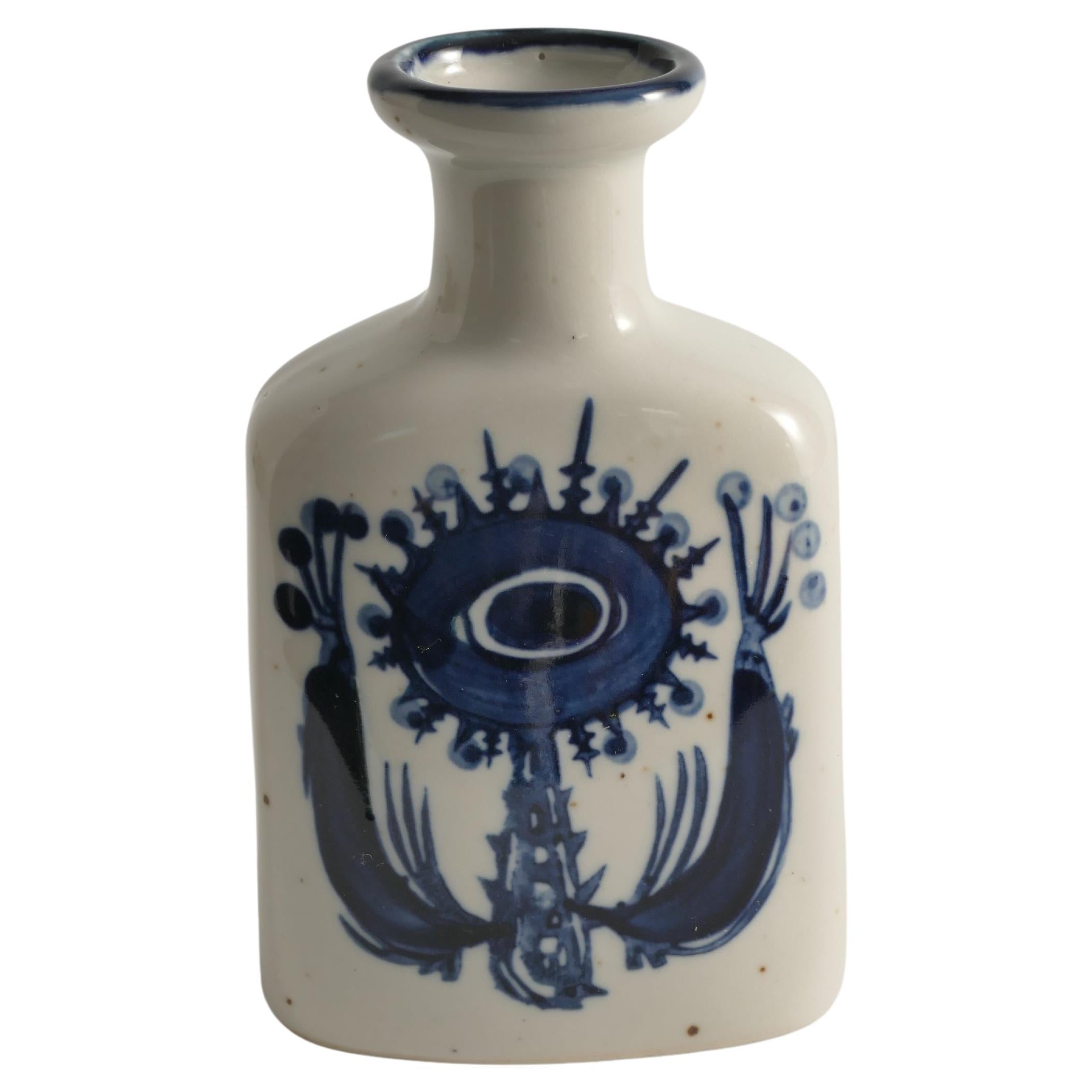 This Scandinavian modern indigo blue flower motif stoneware vase, attributed to Berte Jessen of Royal Copenhagen, is a beautifully crafted piece featuring hand-painted indigo blue motifs on each side. The design depicts both large and small fantasy