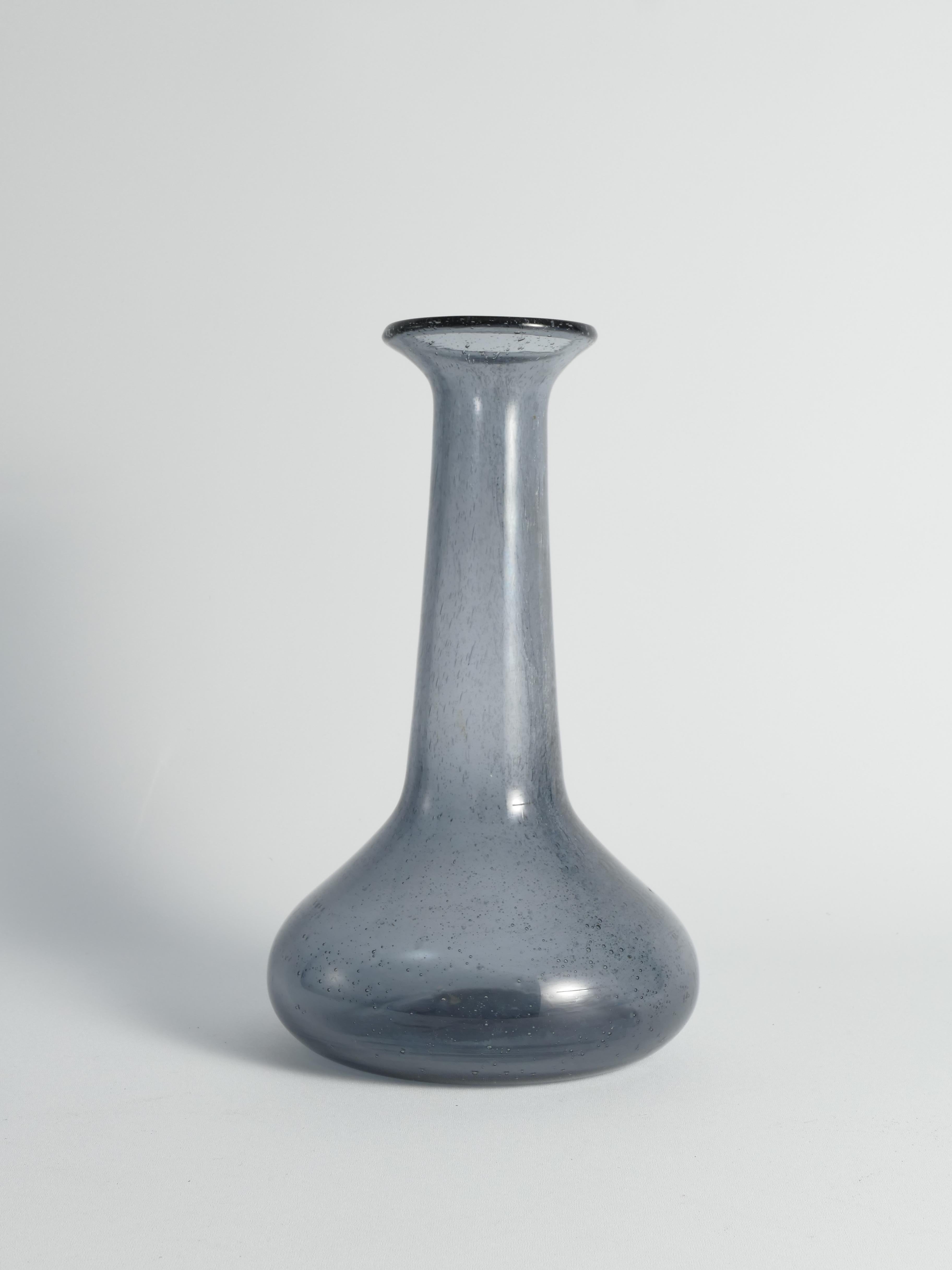 Plongez dans le charme discret de ce vase en verre bleu, créé par les mains expertes de l'artiste Erik Höglund pour Boda glassworks.  Le verre bleu scintillant, avec sa danse ludique de petites bulles, crée une ambiance de beauté délicate.


Ce vase