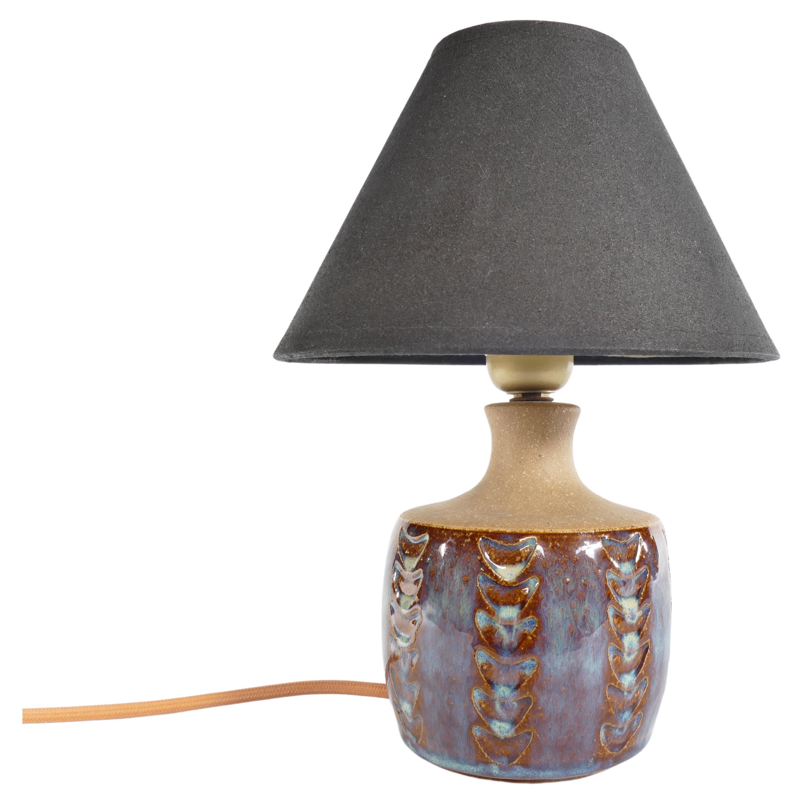 Fabriquée à la main au milieu du XXe siècle, cette exquise lampe de table en grès porte la marque distinctive de Søholm Stentøj. Produite par la célèbre entreprise danoise Soholm Stentoj sur l'île pittoresque de Bornholm, cette lampe capture
