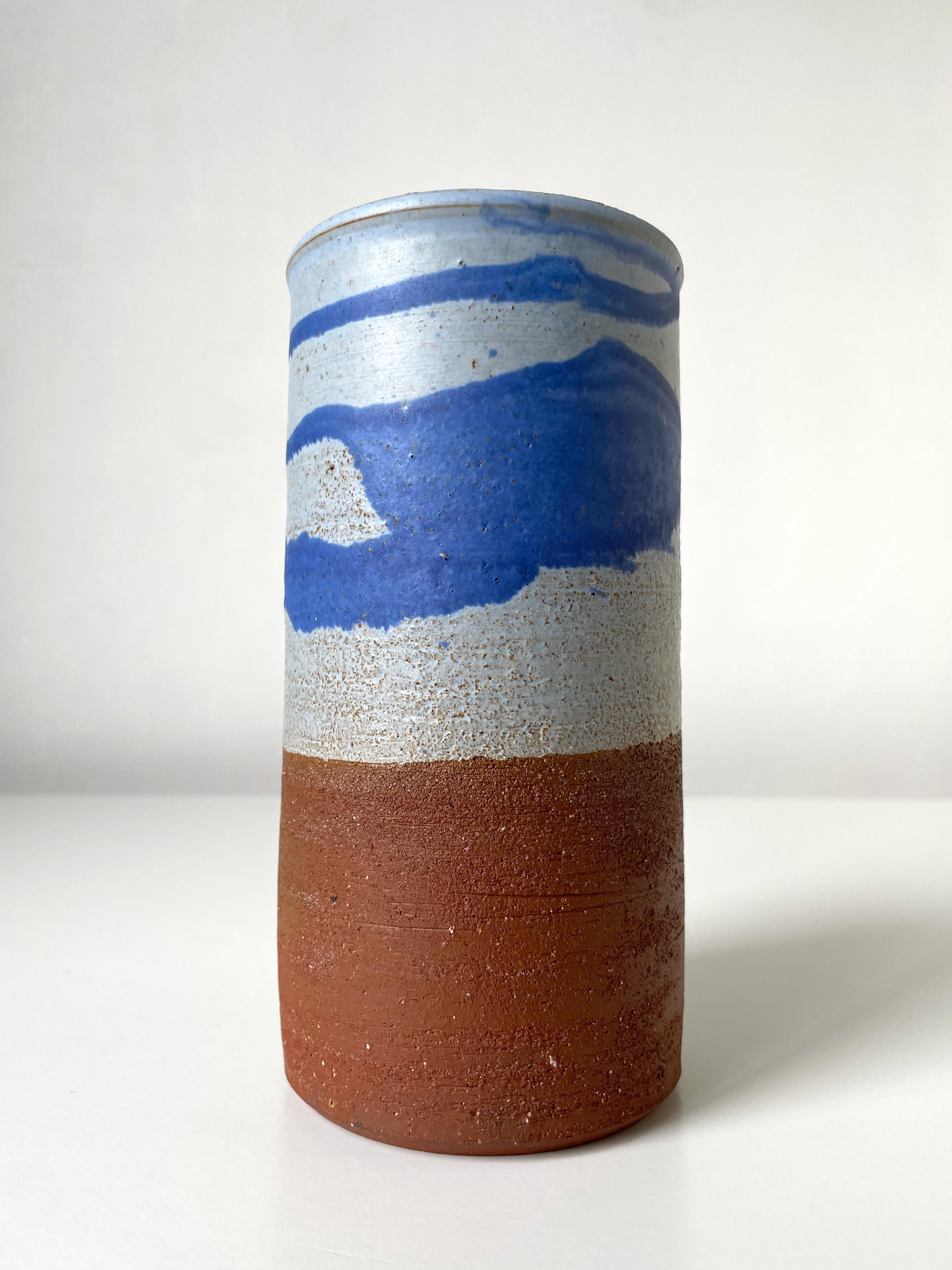 Nordic Modern minimalist hand-painted ceramic vase made in 1969. Cylinder shape with soft top edge. Matte dusty light blue glaze with dark blue organic splash running glaze over raw unglazed bottom part. Light blue glaze on the inside. Stamped and