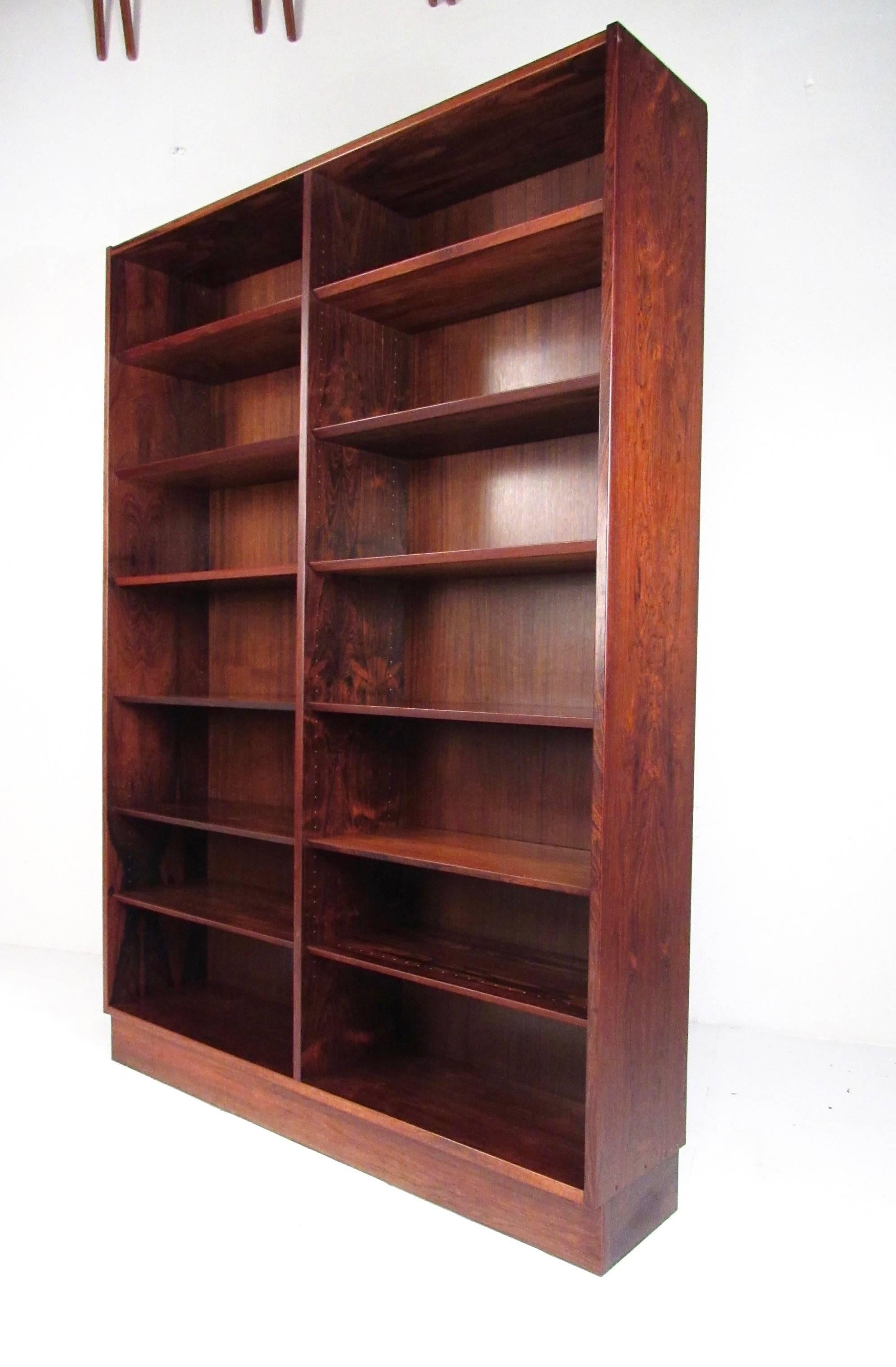 This tall rosewood bookcase features rich Scandinavian Modern wood choice, Mid-Century Modern style, and the Made in Denmark quality control mark. Spacious side-by-side shelf layout with adjustable shelves makes this an elegant and versatile book