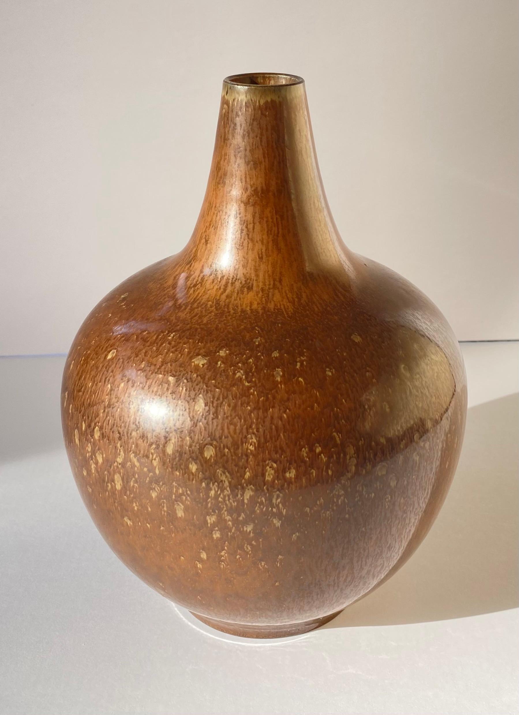 Vase moderne scandinave en céramique, fabriqué à la main et émaillé de brun ambré
 par Gunnar Nylund pour Rorstrand , Suède, c. 1950's.
Signé en bas, R avec 3 couronnes, Suède, et GN.