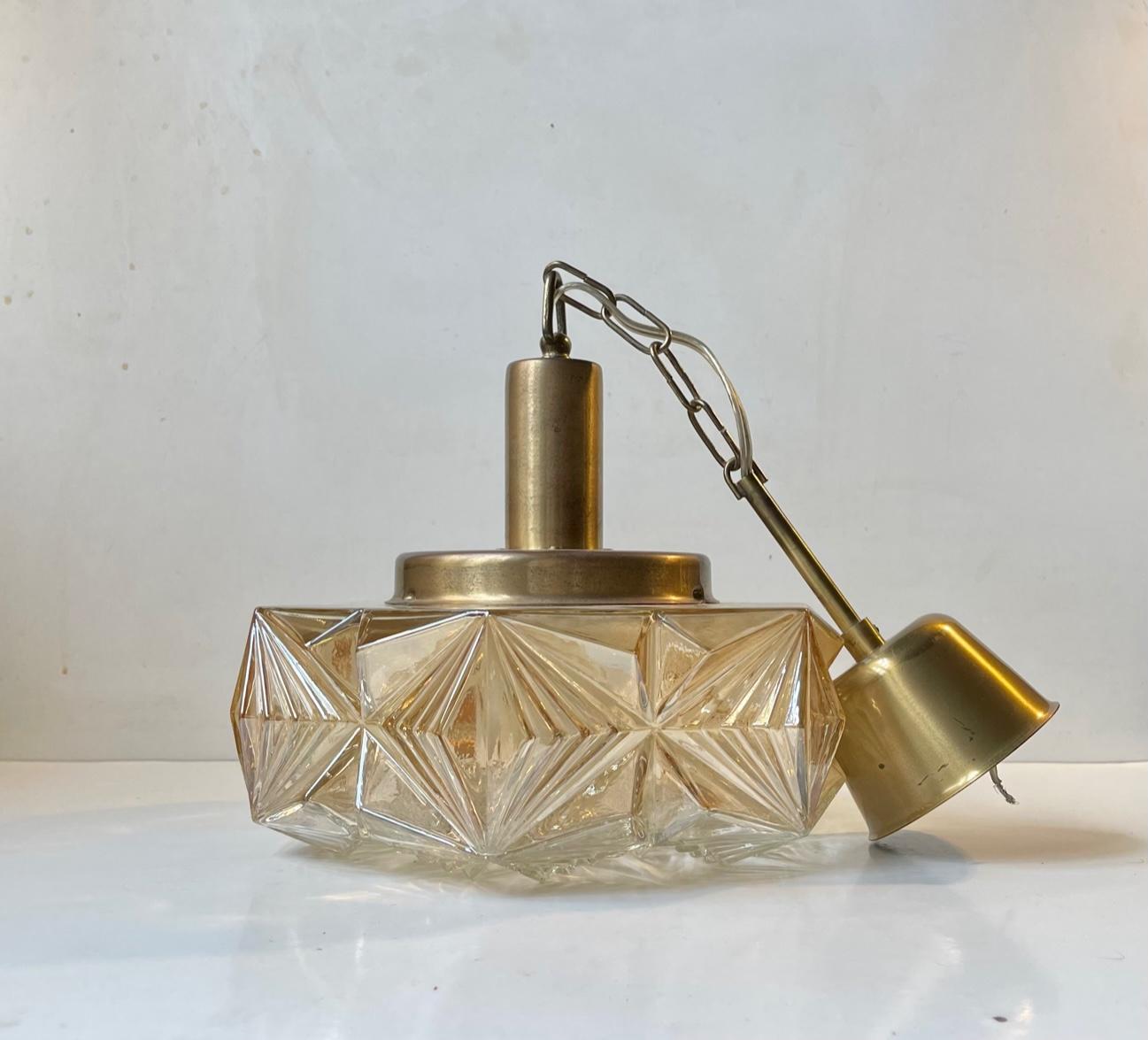 Pendant light designed and manufactured by Danish design trio Vitrika during the 1960s. The name Vitrika, or Vi-Tri-Ka means 'The three of us can do it'. The lamp features a geometric outer amber colored glass shade and a top, chain and original