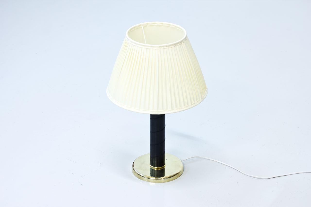 Swedish table lamp from the 1960s signed GMA on the bottom. Made of cast iron base, polished brass and leatherette wrapping. Rewired. New hand sewn, off-white pleated shade in chintz fabric.