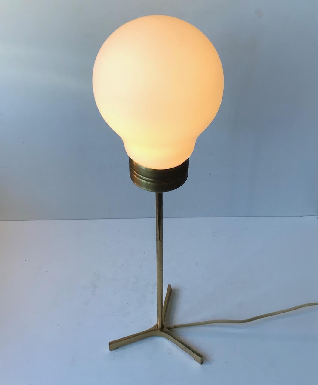 A solid brass tripod table light mounted with a bulb shaped shade in mat opaline glass. Manufactured and designed anonymously in Sweden around the 1960s presumably by either Falkenberg or Bergboms Bergboms belysning/amaturer. Measurements: Height: