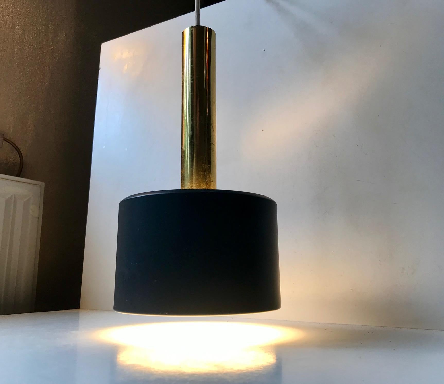 This Scandinavian pendant light made from brass and dark grey powder coated aluminum. At first glance it looks similar to Jo Hammerborg's 'Club' pendant for Fog & Mørup. This one is slightly different. It was manufactured during the 1960s probably