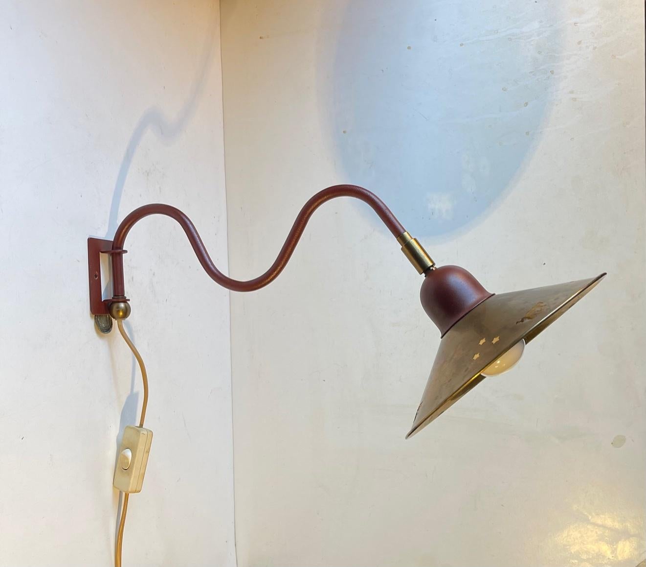 Fully adjustable wall lamp composed of a Burgundy swing-arm steel stem and a partially perforated solid brass shade. It was manufactured during the 1960s by E. S. Horn in Denmark. The style is reminiscent of Svend Aage Holm-Sørensen, Paavo Tynell