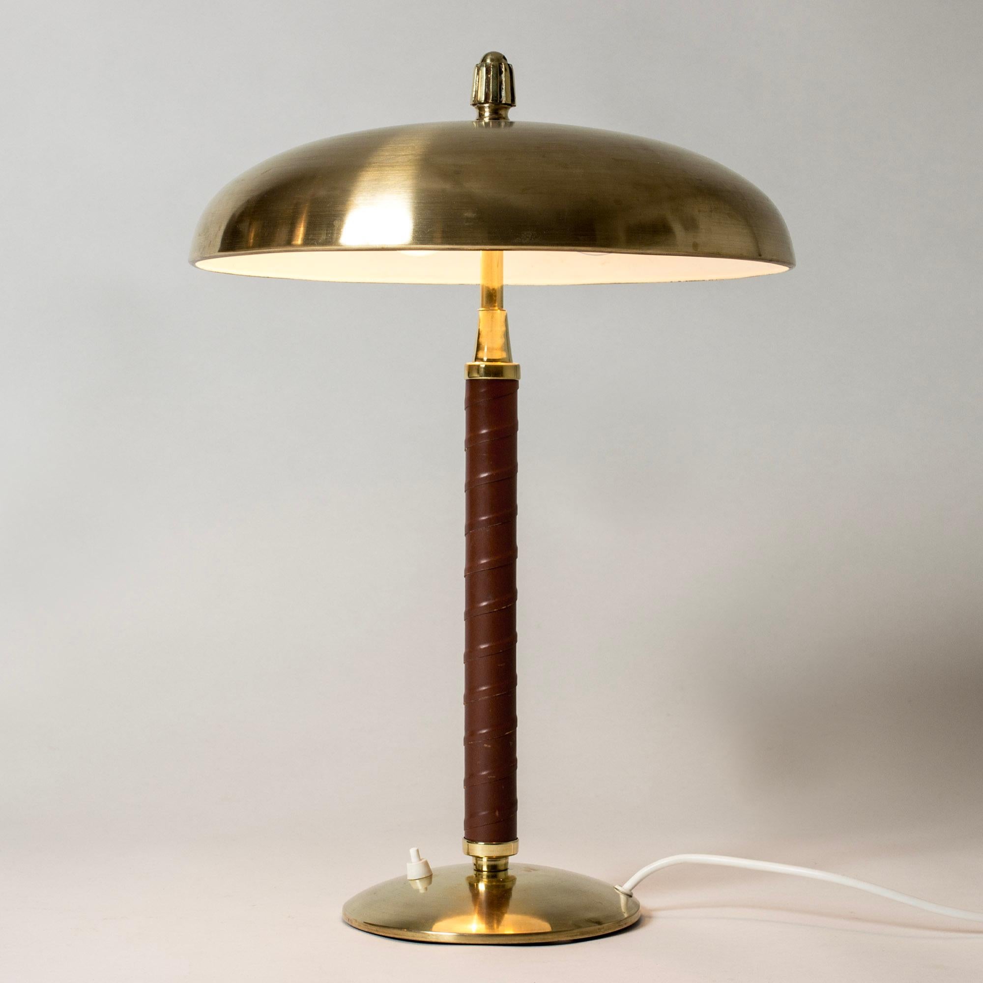 Elegant table lamp from Einar Bäckström, made from brass with a leather wound stem. Decorative knob on top of the shade.