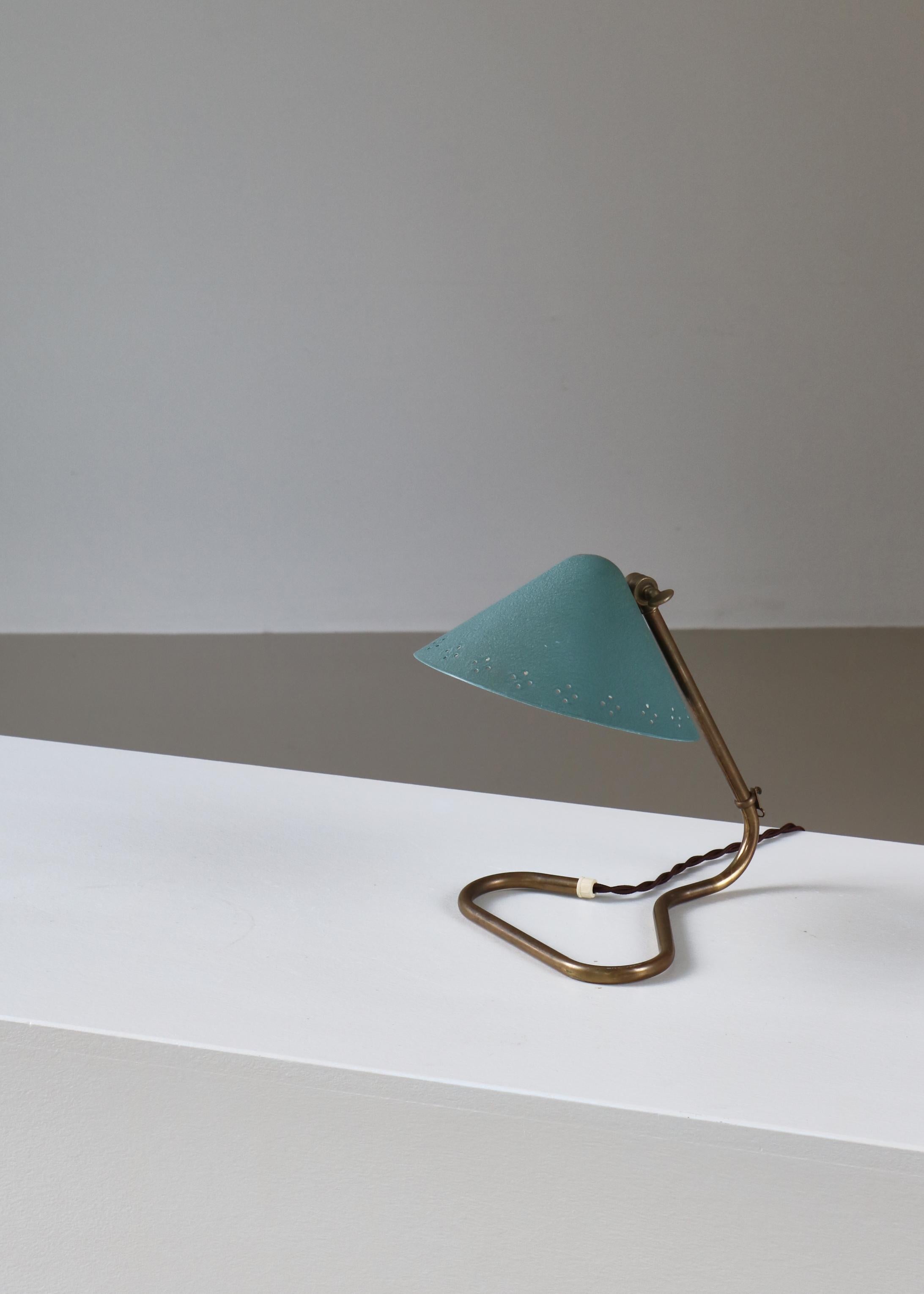 Lampe de table à abat-jour perforé 'GK14' d'Erik Warna des années 1950. Exécuté en métal peint perforé et en laiton patiné. L'abat-jour est réglable et peut pivoter vers le haut ou vers le bas. Produit par Gnosjö Konstsmide Rydahls en Suède dans les