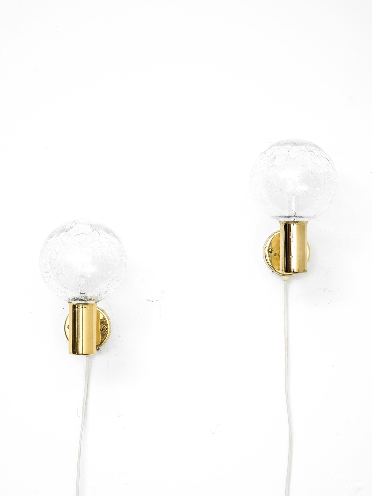 Pair of 1960s wall lamps model V-149 designed by Hans-Agne Jakobsson. Produced by Hans-Agne Jakobsson AB in Markaryd, Sweden.

Clear glass globes with broken effect that gives superb atmospheric light. Wall-mounted brass part is in nice