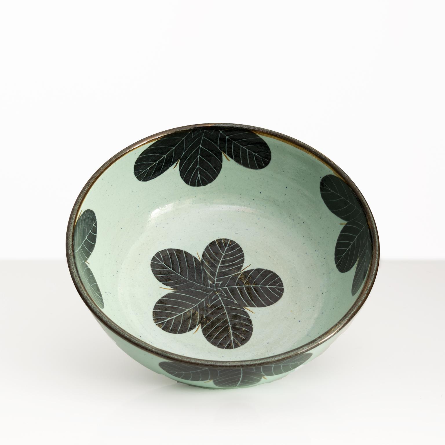 A large unique studio bowl by Britt-Louise Sundell for Gustavsberg, Sweden. The bowl has a jade colored glaze and is detail in dark blue-black flowers. Signed on the bottom, circa 1960’s.

Measures: Diameter: 13”, Height: 5”.