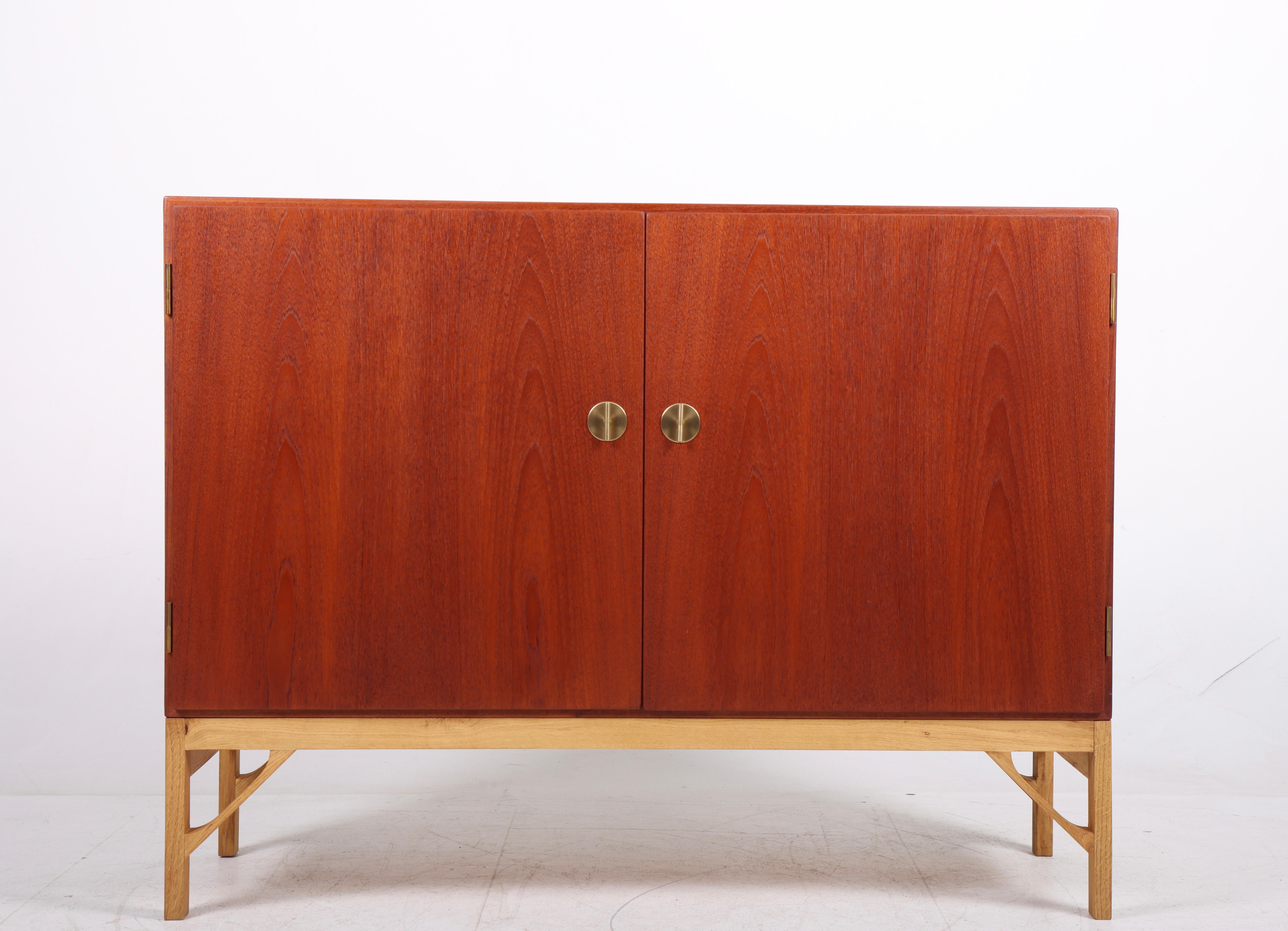China cabinet in teak and oak with stunning brass hardware and maple Interior. Designed by MAA. Børge Mogensen in 1958, this piece is made by CM Madsen cabinetmakers Denmark in the 1960s. Great original condition.