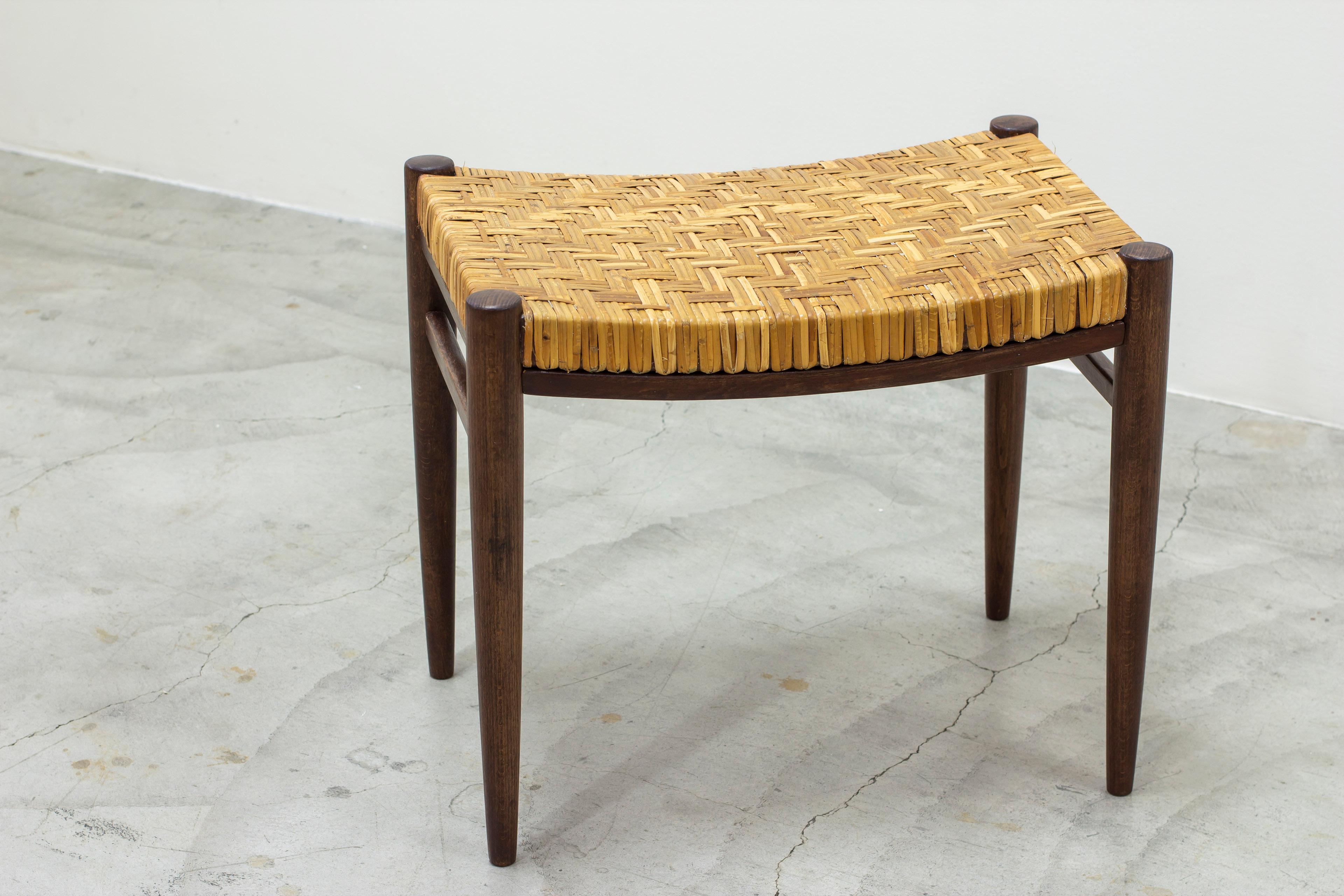 Stool produced in Sweden by Gemla fabriker during the 1950s. Made from dark stained beech with hand woven cane seat. Lovely romb pattern on the cane seat. Very good vintage condition with light age related wear and patina. Some cane straws have been